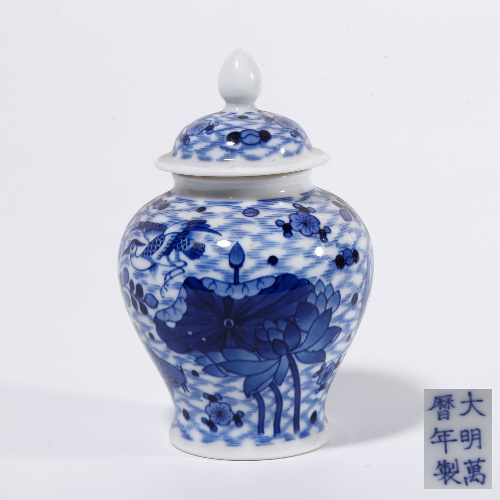 A BLUE AND WHITE LIDDED JAR WITH LOTUS AND SURPLUS YEAR PATTERN: Blue and White Lidded Jar with Lotus and Surplus Year Pattern