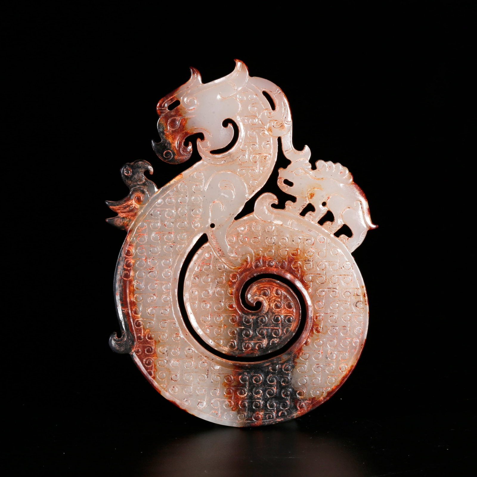 A HETIAN JADE CARVED PENDANT WITH DRAGON MOTIF: Hetian jade carved pendant with dragon motif