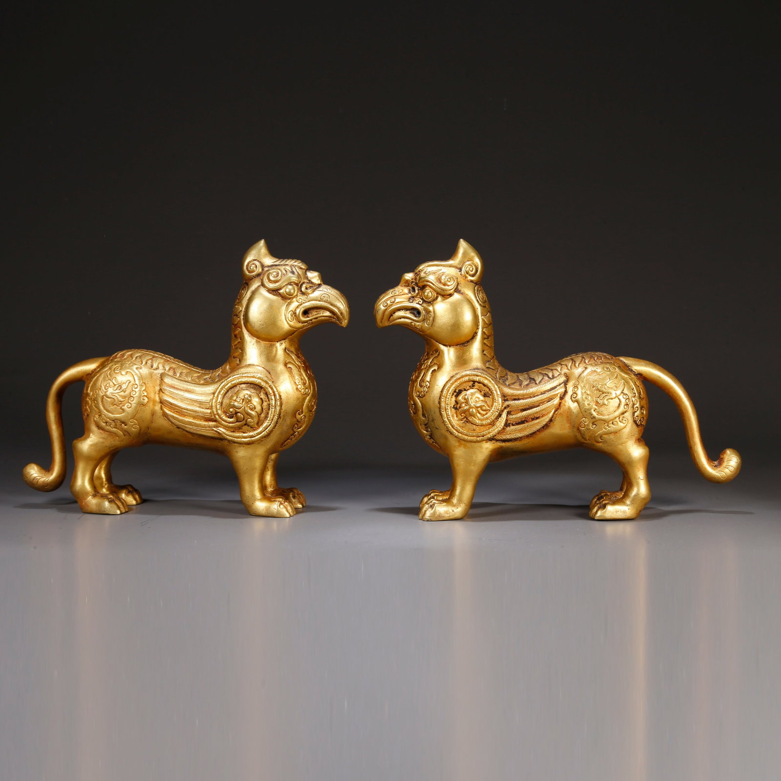A GILT BRONZE AUSPICIOUS BEAST MOTIF ORNAMENTS (PAIR): Gilt bronze auspicious beast motif ornaments (pair)