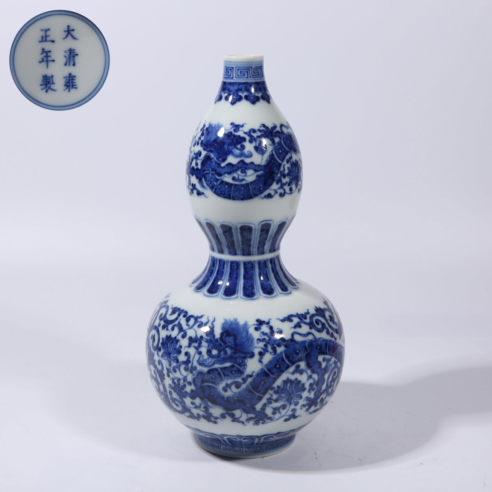 A BLUE AND WHITE "DRAGON THROUGH FLOWERS" GOURD VASE: Blue and white "dragon through flowers" gourd vase