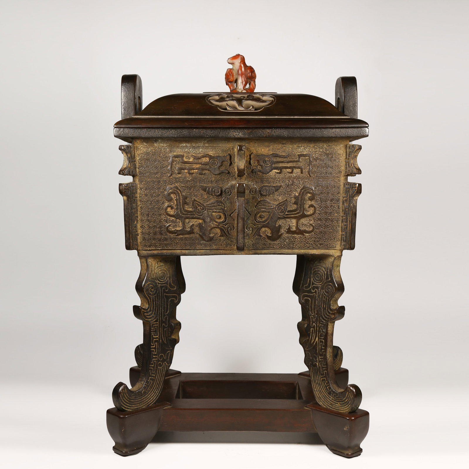 A BRONZE DING-SHAPED CENSER WITH FOUR LEGS AND ANIMAL-FACE MOTIFS, UPRIGHT FINIALS (1 of 10)