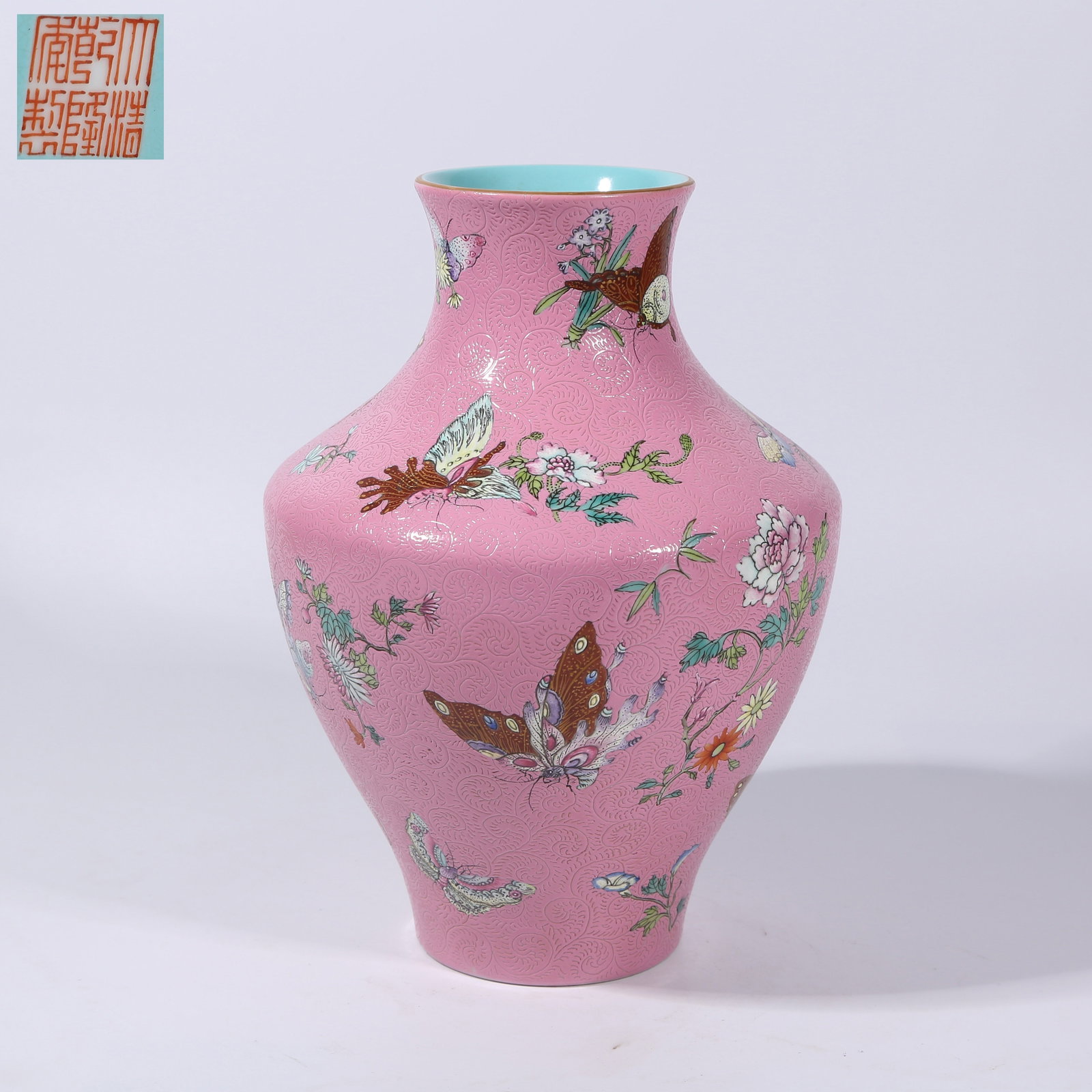 A PALACE-PINK GROUND PRESSED FAMILLE ROSE FLORAL AND BUTTERFLY PATTERN ZUN: Palace-pink ground pressed famille rose floral and butterfly pattern zun