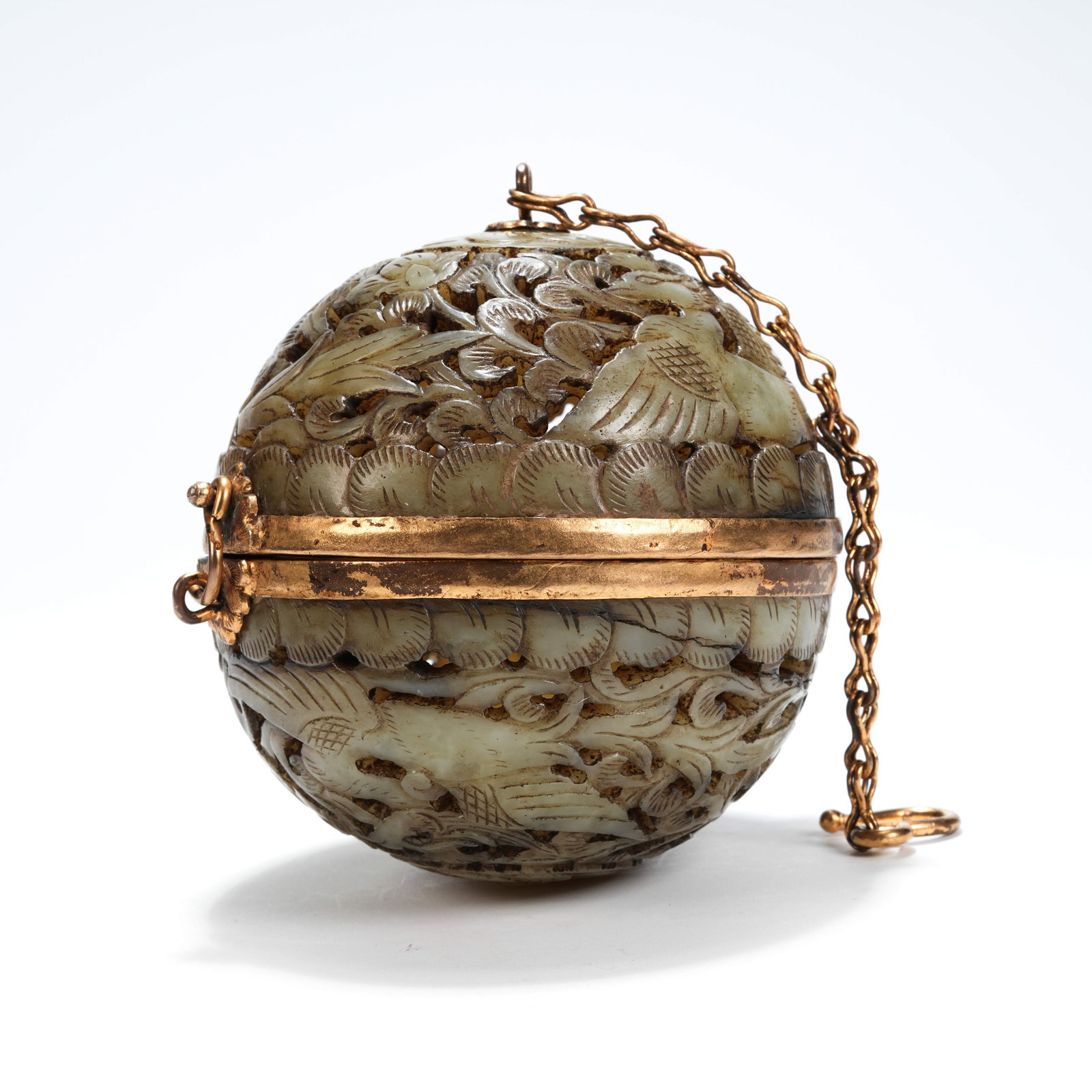 A ARCHAIC JADE SPHERICAL INCENSE BURNER WITH OPENWORK PHOENIX PATTERN AMONG FLOWERS: Archaic jade spherical incense burner with openwork phoenix pattern among flowers