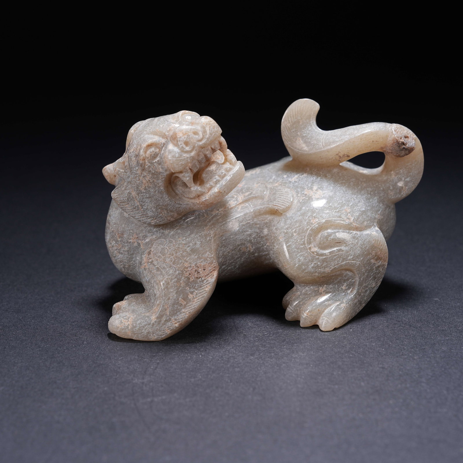 A ARCHAIC JADE CURLED-TAIL BEAST FIGURINE (1 of 8)
