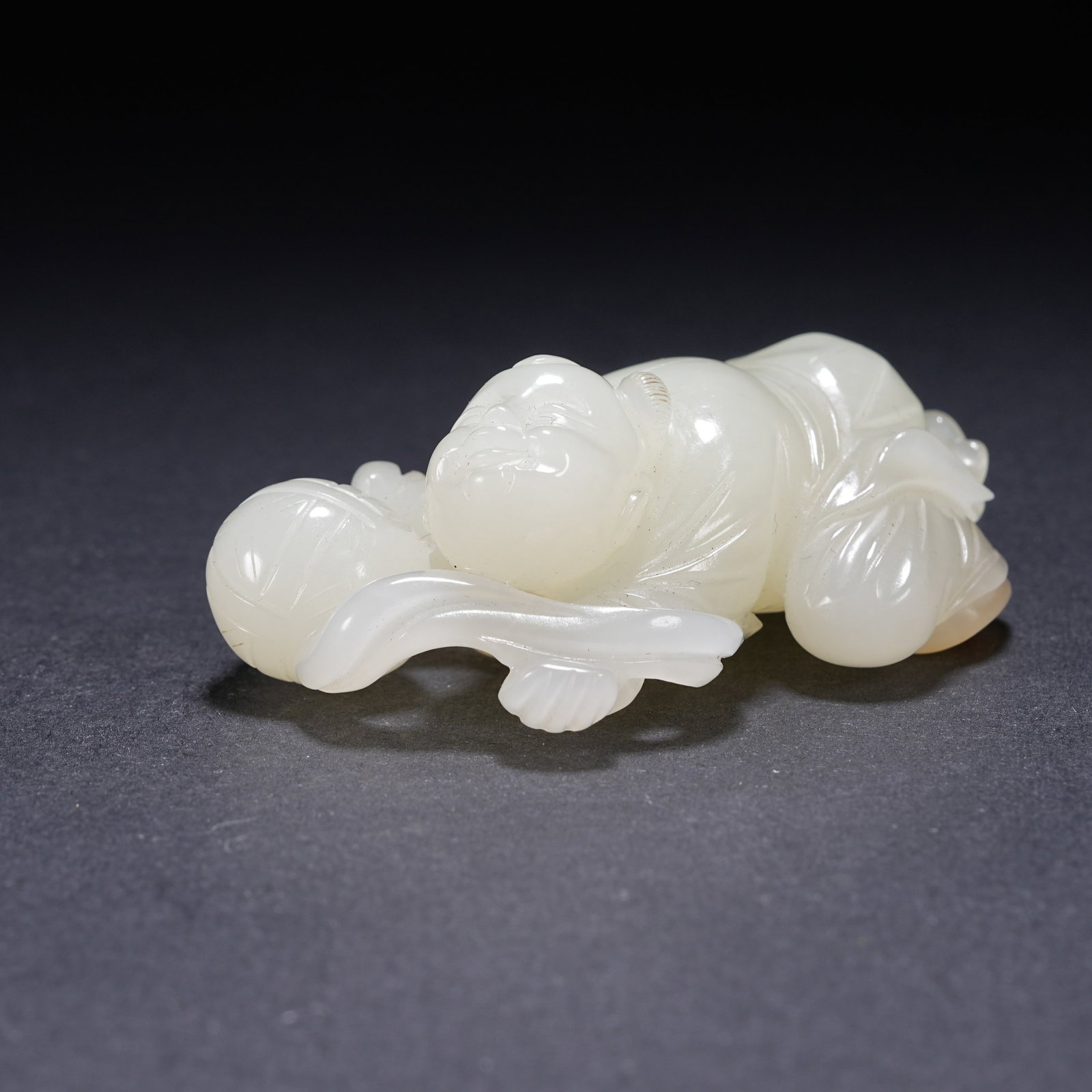 A HETIAN WHITE JADE RECUMBENT BOY FIGURINE (1 of 8)