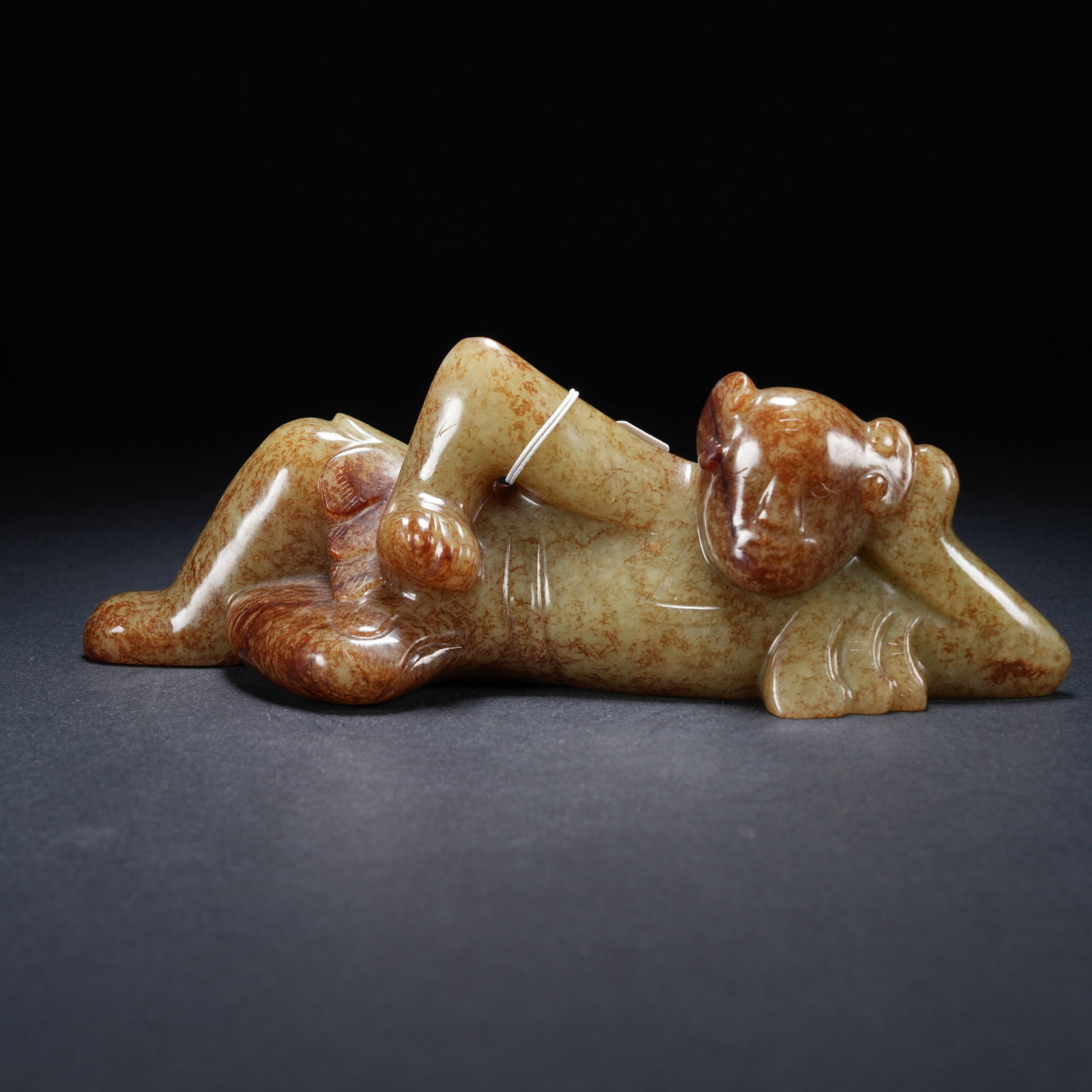 A ARCHAIC JADE RECLINING BOY FIGURINE (1 of 9)