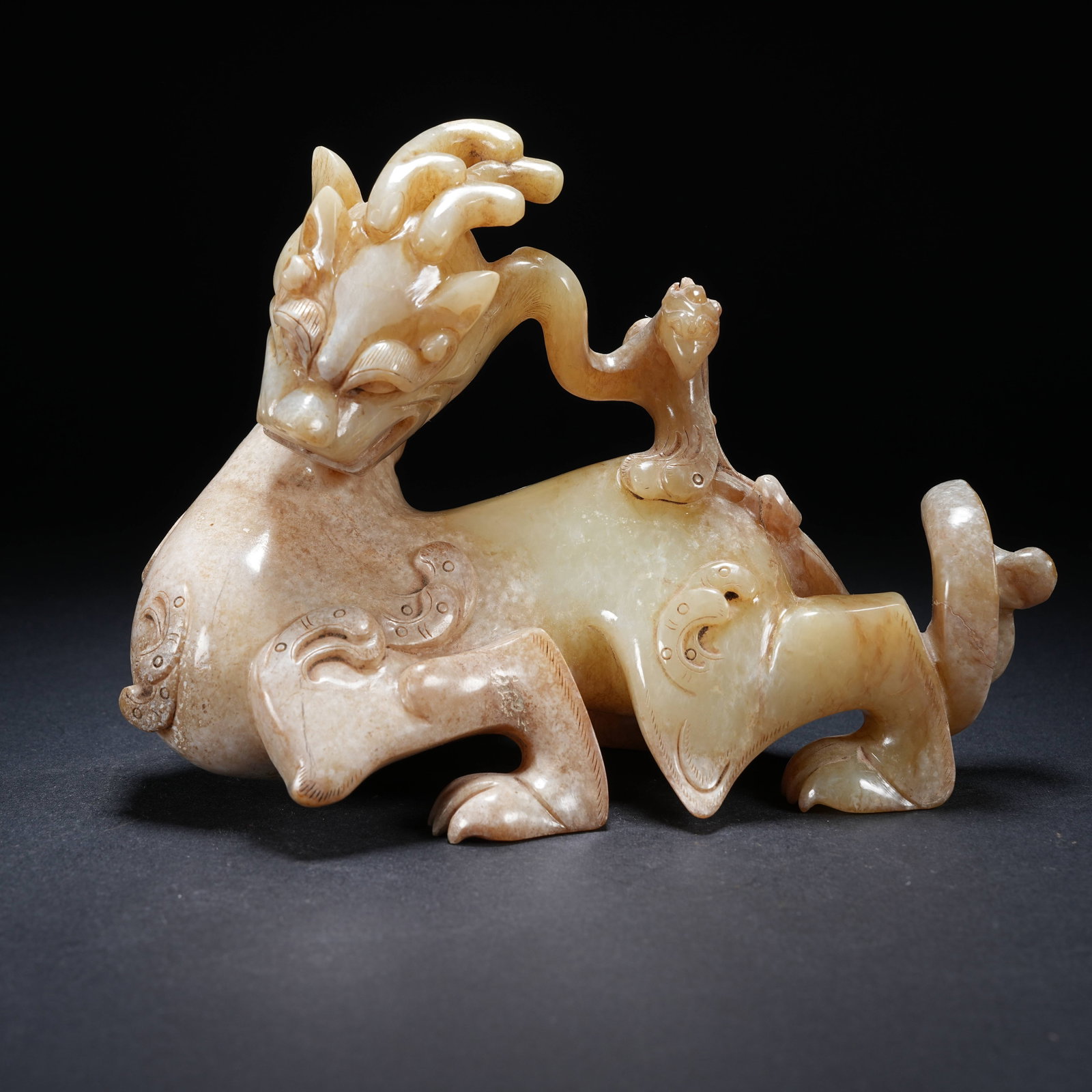 A ARCHAIC JADE ORNAMENT OF AUSPICIOUS BEAST BEARING A PHOENIX: Archaic jade ornament of auspicious beast bearing a phoenix