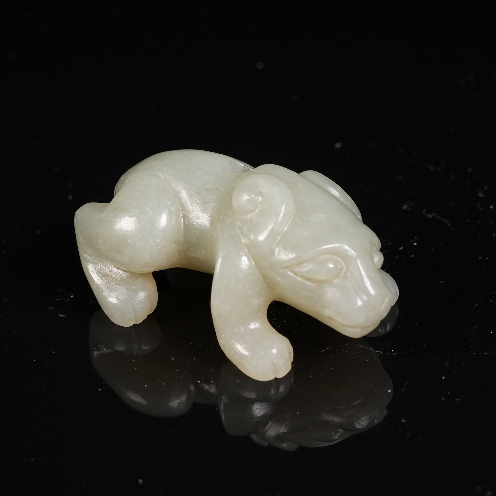 A HETIAN JADE RECLINING BEAST PENDANT: Hetian Jade Reclining Beast Pendant