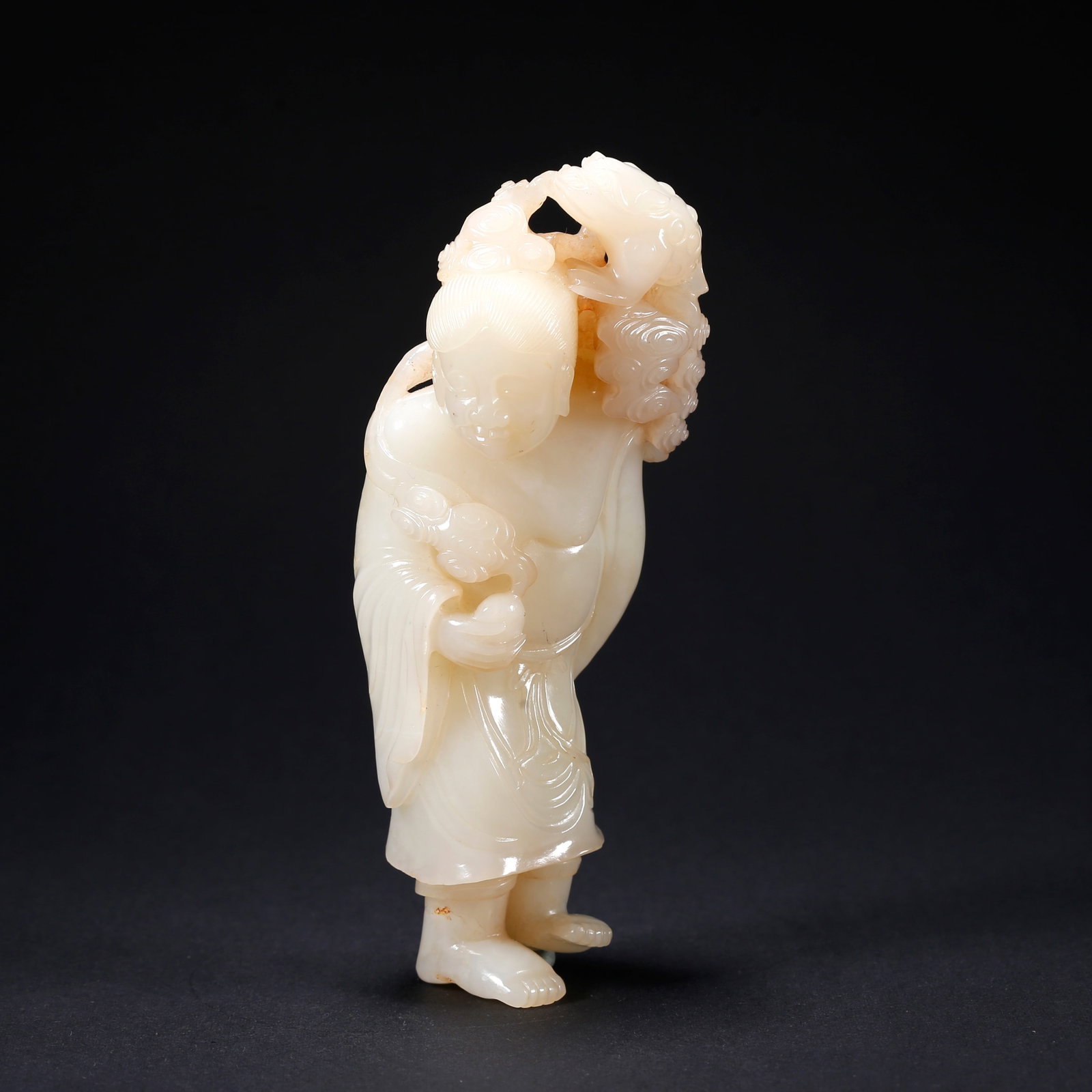 A HETIAN JADE LIU HAI PLAYING WITH THE GOLDEN TOAD FIGURINE: Hetian Jade Liu Hai Playing with the Golden Toad Figurine