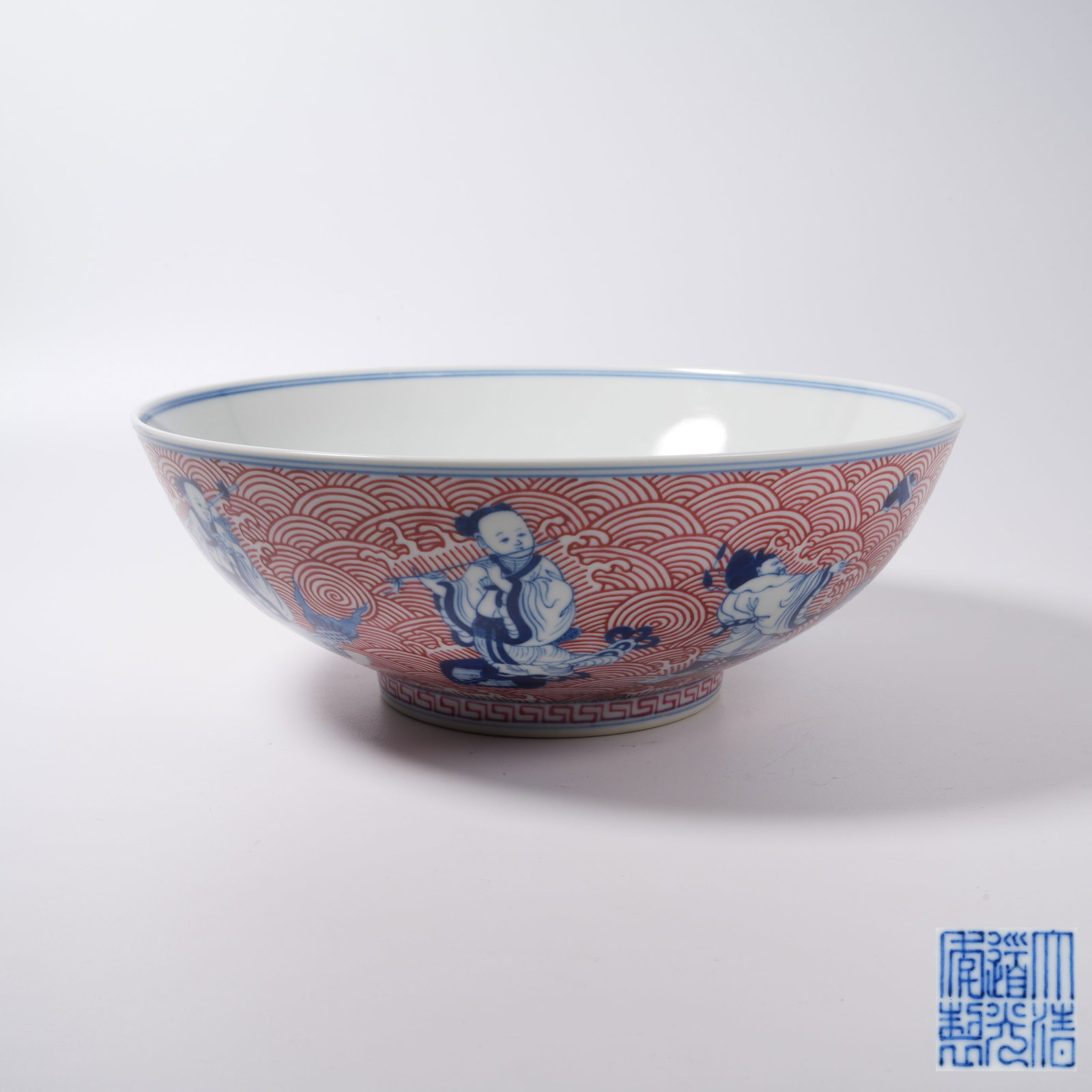 A BLUE AND WHITE IRON RED LARGE BOWL WITH EIGHT IMMORTALS CROSSING THE SEA PATTERN: Blue and White Iron Red Large Bowl with Eight Immortals Crossing the Sea Pattern