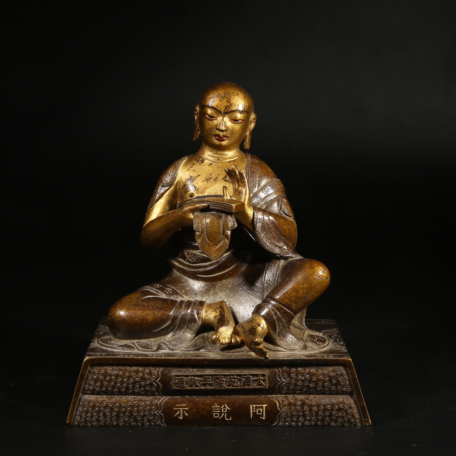A BRONZE MUD-GILDED STATUE OF AN ARHAT: Bronze Mud-Gilded Statue of an Arhat