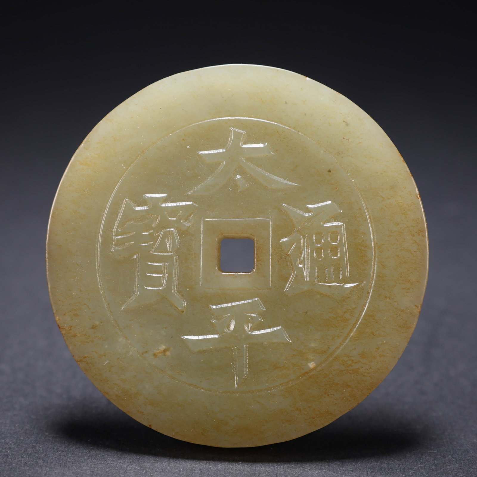 A HETIAN JADE "PEACE AND PROSPERITY" JADE COIN (1 of 9)