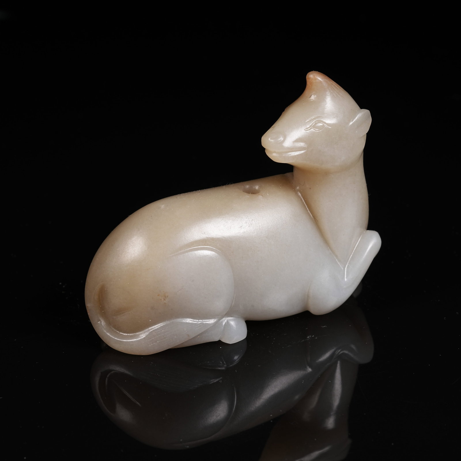 A HETIAN JADE RECLINING BEAST PENDANT: Hetian Jade Reclining Beast Pendant