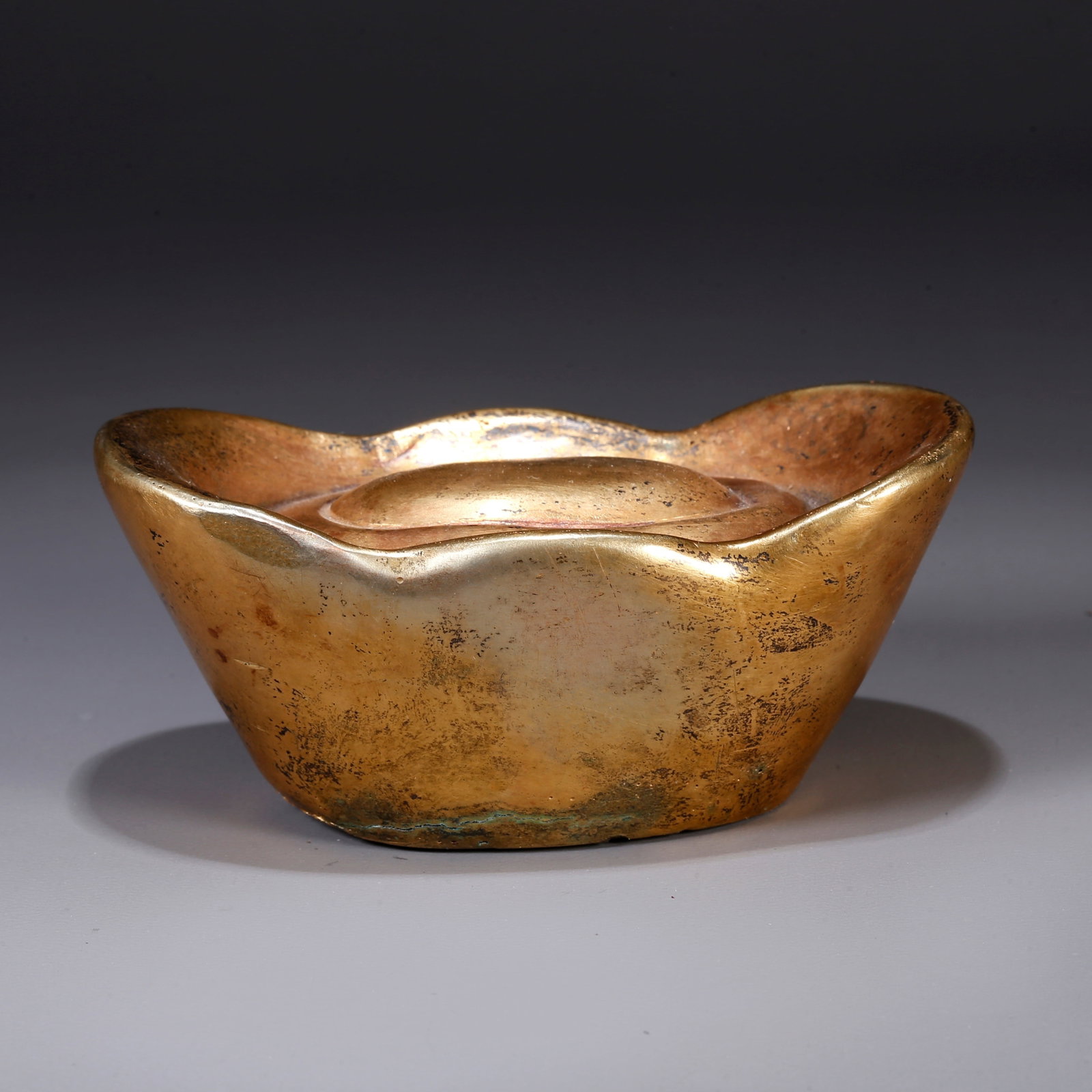 A GILT BRONZE SYCEE (INGOT): Gilt bronze sycee (ingot)