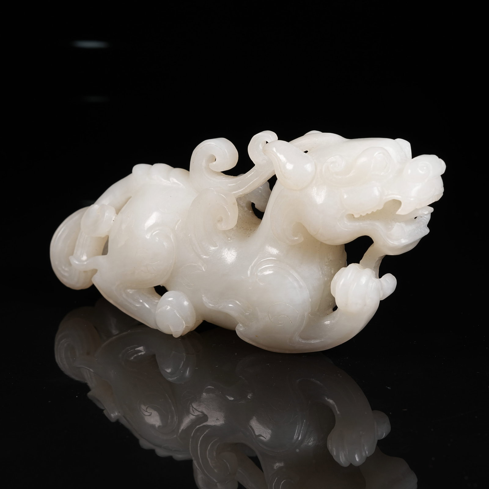 A WHITE HETIAN JADE AUSPICIOUS BEAST ORNAMENT (1 of 6)