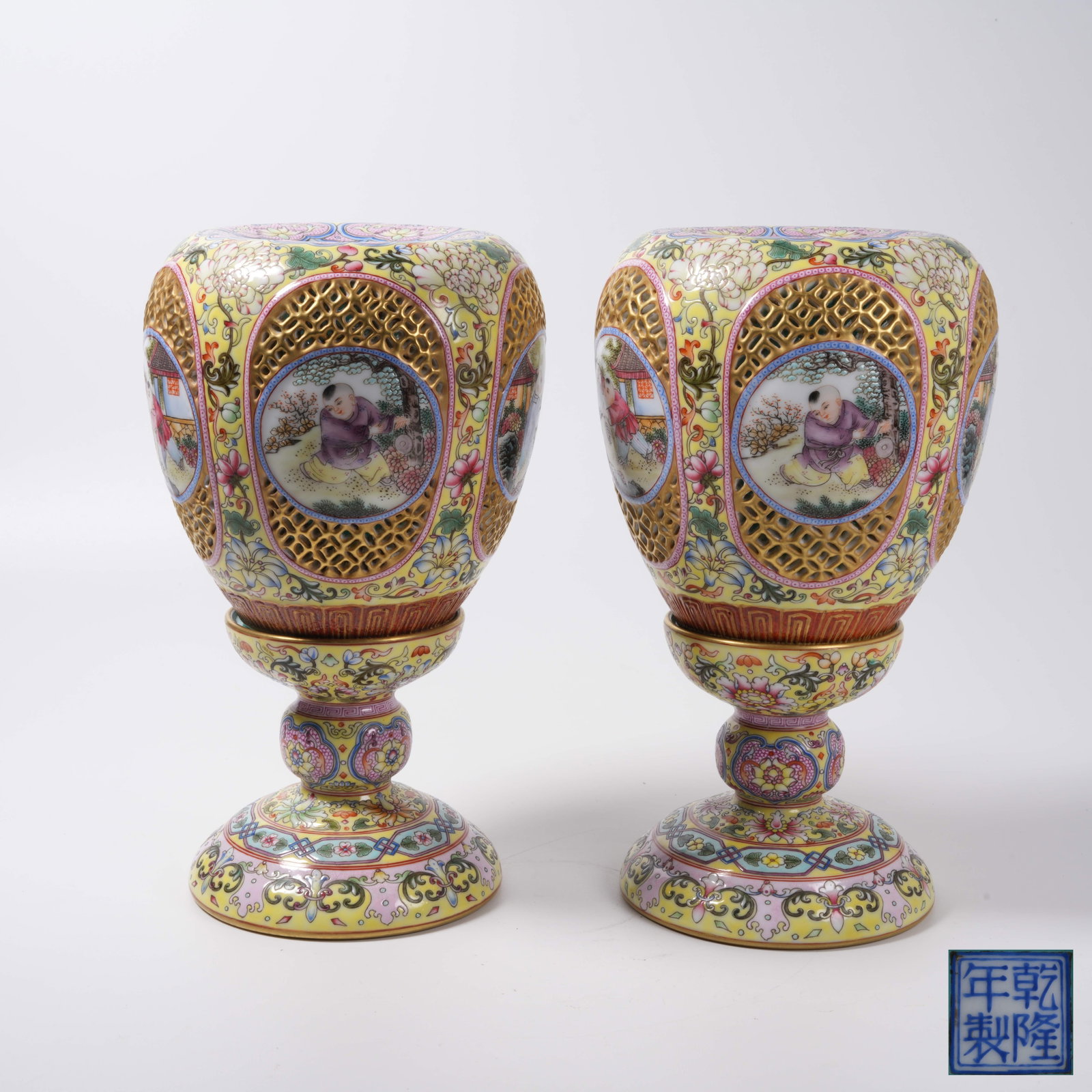 A SET OF YELLOW GROUND OPENWORK FAMILLE ROSE CANDLESTICKS WITH CHILDREN PLAYING PATTERN: Set of Yellow Ground Openwork Famille Rose Candlesticks with Children Playing Pattern