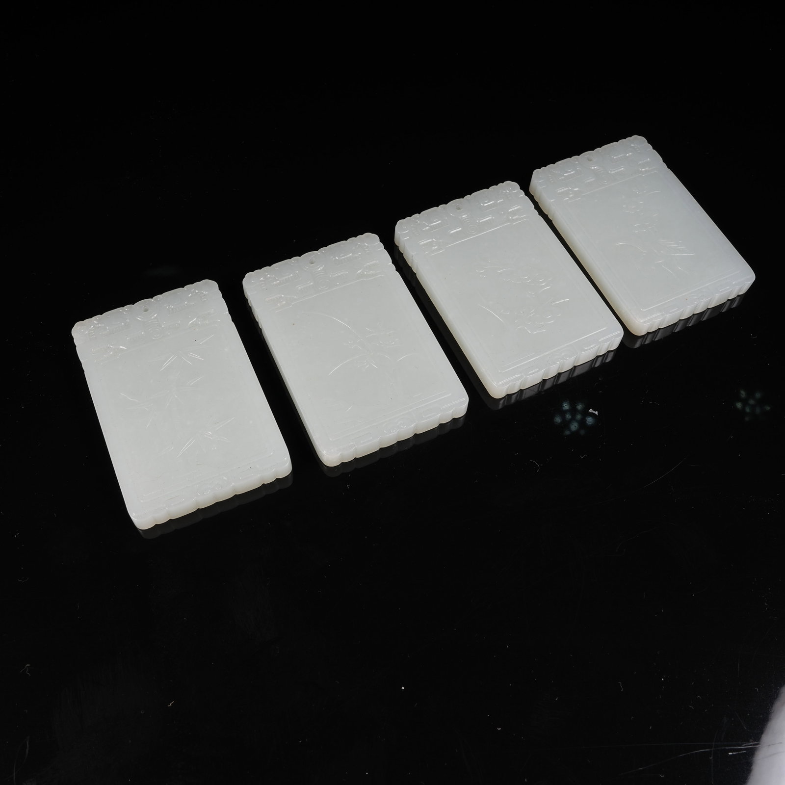 A SET OF WHITE HETIAN JADE PLAQUES WITH PLUM, ORCHID, BAMBOO AND CHRYSANTHEMUM PATTERNS: Set of White Hetian Jade Plaques with Plum, Orchid, Bamboo and Chrysanthemum Patterns