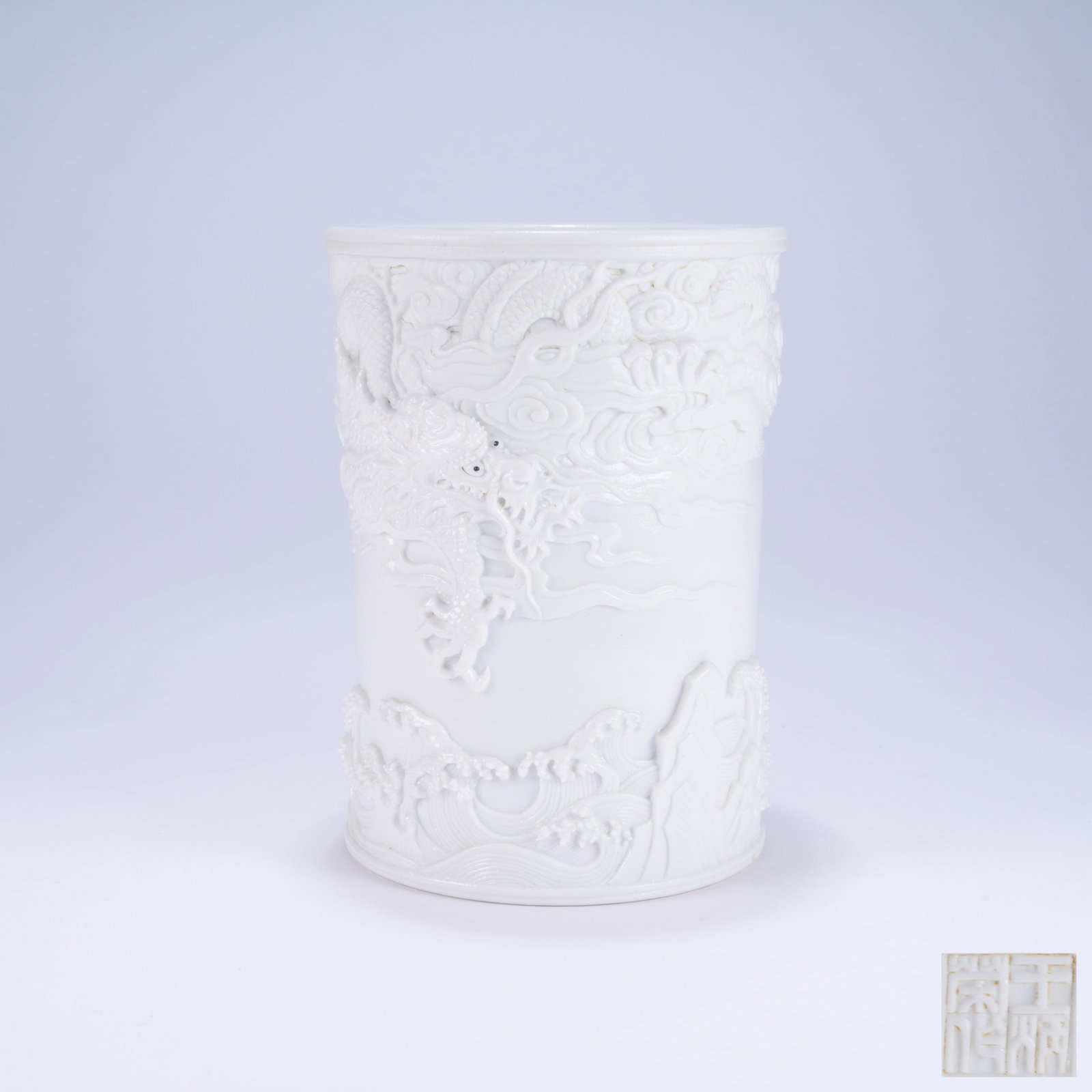 A WHITE PORCELAIN SCULPTED BRUSH POT WITH CLOUD AND DRAGON PATTERN (1 of 9)