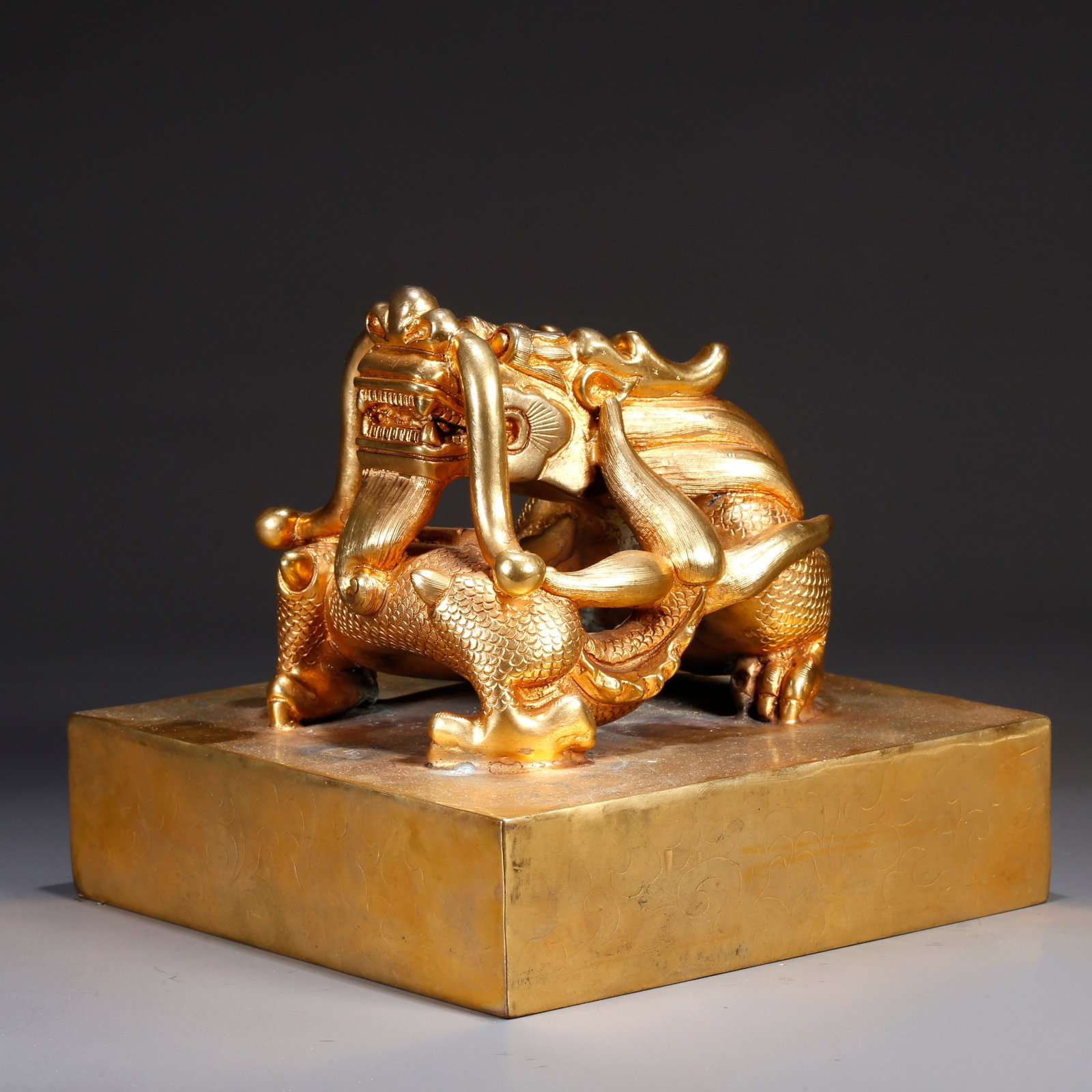 A GILT BRONZE SEAL WITH CHI-DRAGON KNOB: Gilt bronze seal with chi-dragon knob