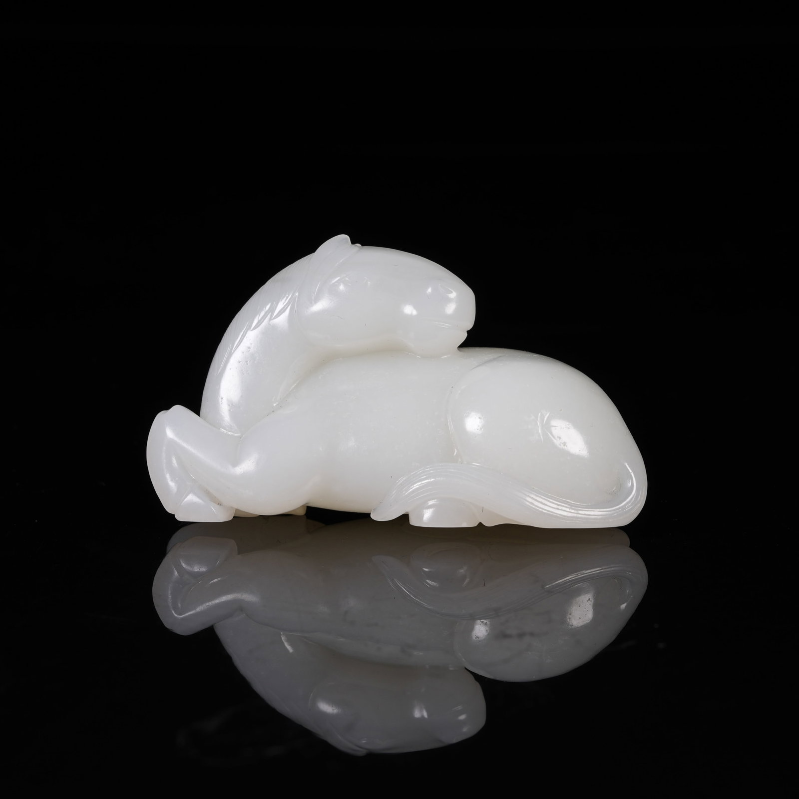 A WHITE HETIAN JADE RECUMBENT HORSE ORNAMENT: White Hetian Jade Recumbent Horse Ornament