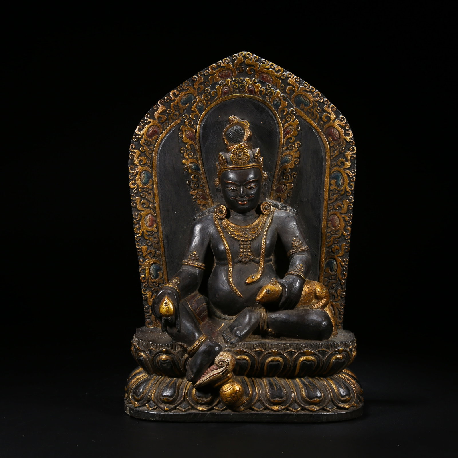 A BLACK STONE STATUE OF YELLOW JAMBHALA: Black Stone Statue of Yellow Jambhala