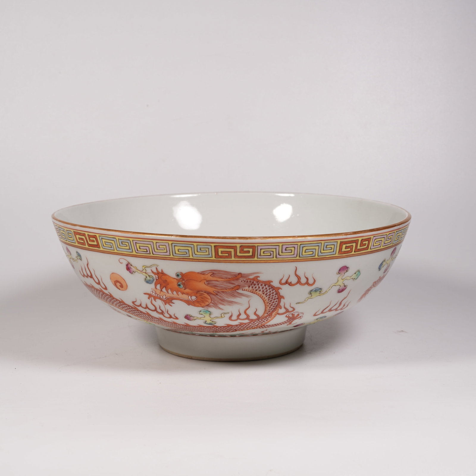 A LARGE FAMILLE ROSE BOWL WITH IRON-RED SEA WAVE AND DRAGON PATTERN: Large Famille Rose Bowl with Iron-Red Sea Wave and Dragon Pattern