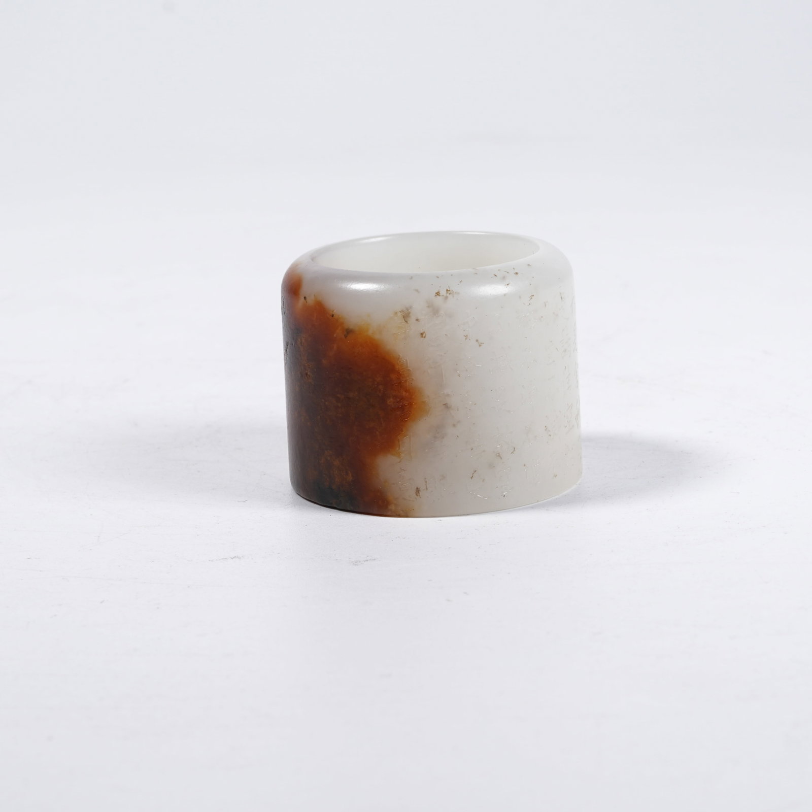 A HETIAN JADE THUMB RING ENGRAVED WITH HEART SUTRA: Hetian Jade Thumb Ring Engraved with Heart Sutra