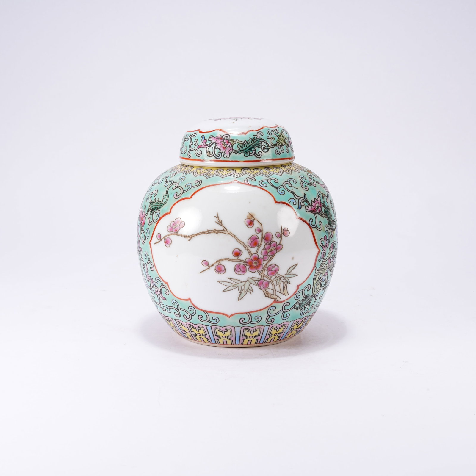 A TURQUOISE-GROUND LIDDED JAR WITH PANELED FAMILLE ROSE FLORALS: Turquoise-ground Lidded Jar with Paneled Famille Rose Florals