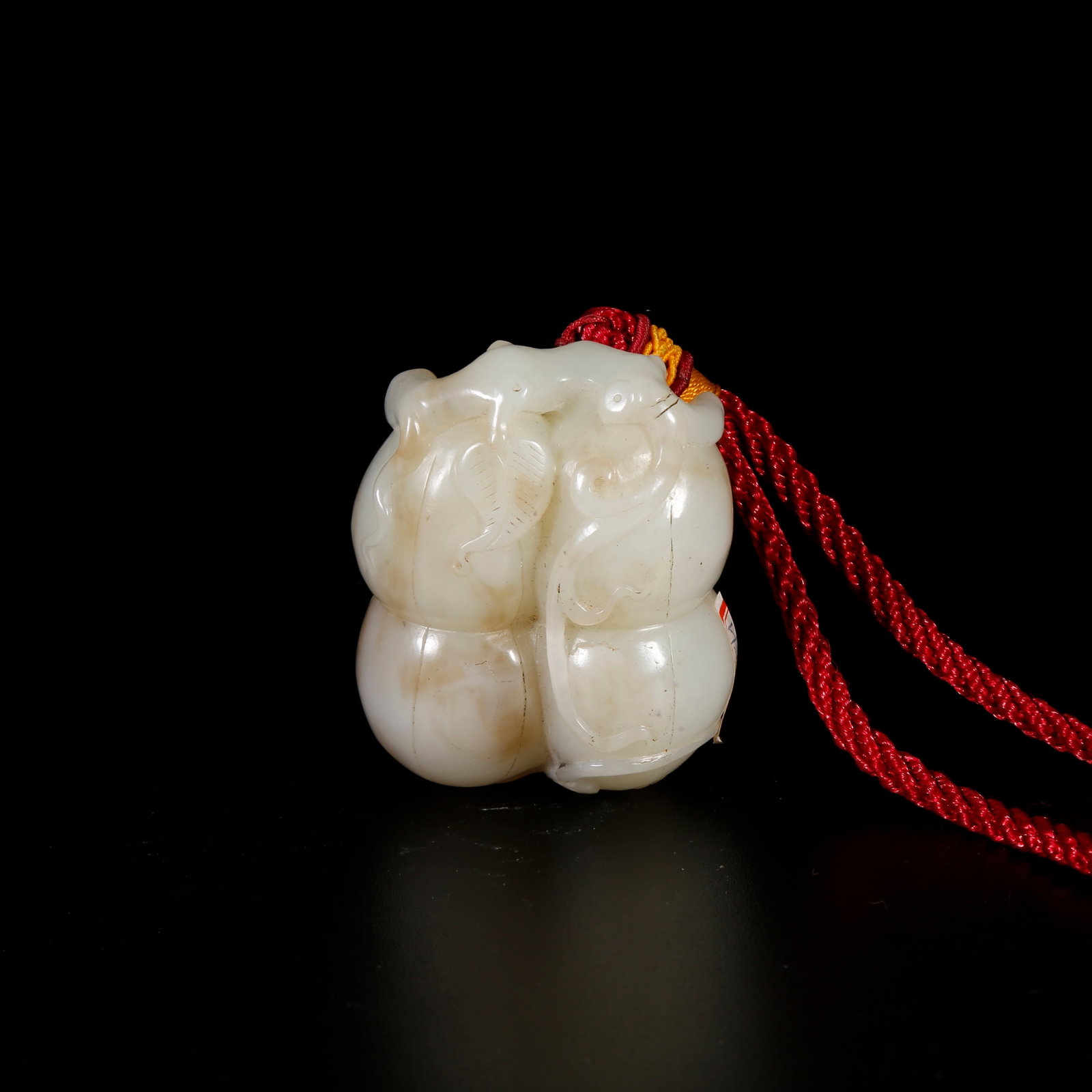 A HETIAN JADE HANDHELD ORNAMENT CARVED IN GOURD FORM: Hetian Jade Handheld Ornament Carved in Gourd Form