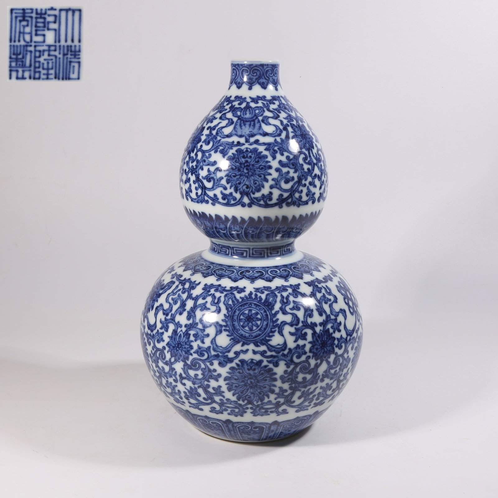 A BLUE-AND-WHITE GOURD-SHAPED VASE WITH WESTERN LOTUS AND EIGHT AUSPICIOUS SYMBOLS DESIGN: Blue-and-White Gourd-Shaped Vase with Western Lotus and Eight Auspicious Symbols Design