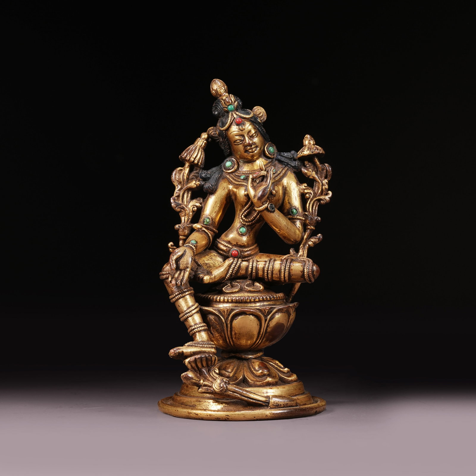A GILT BRONZE STATUE OF GREEN TARA INLAID WITH GEMS: Gilt Bronze Statue of Green Tara Inlaid with Gems