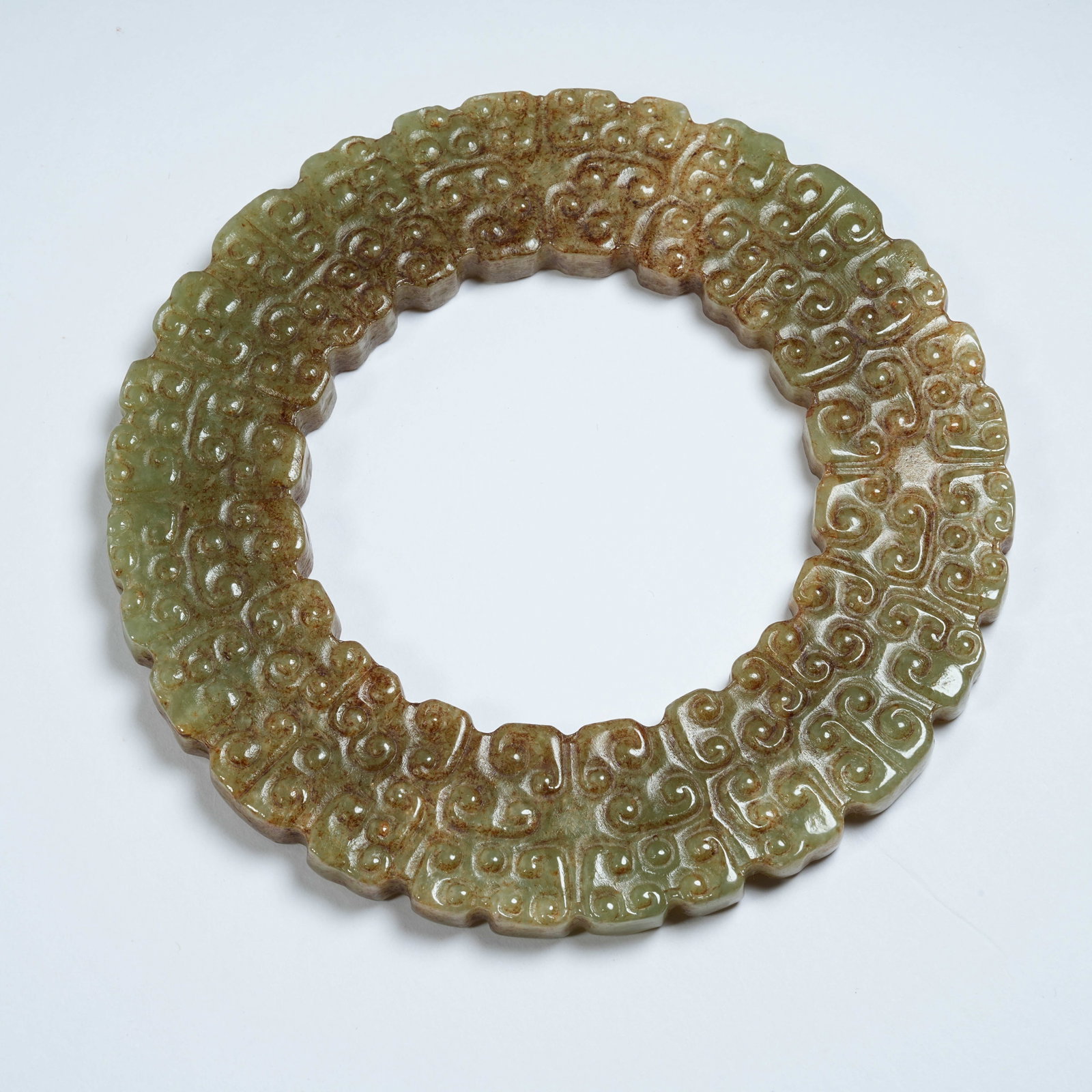 A ANCIENT JADE BI WITH INTERLOCKING CLOUD PATTERNS: Ancient Jade Bi with Interlocking Cloud Patterns