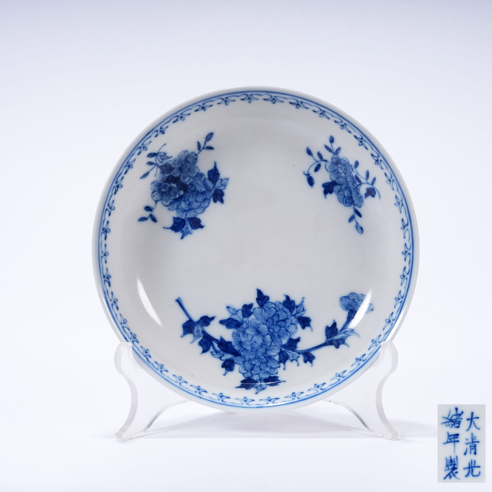 A BLUE AND WHITE PLATE WITH FLORAL PATTERNS: Blue and White Plate with Floral Patterns