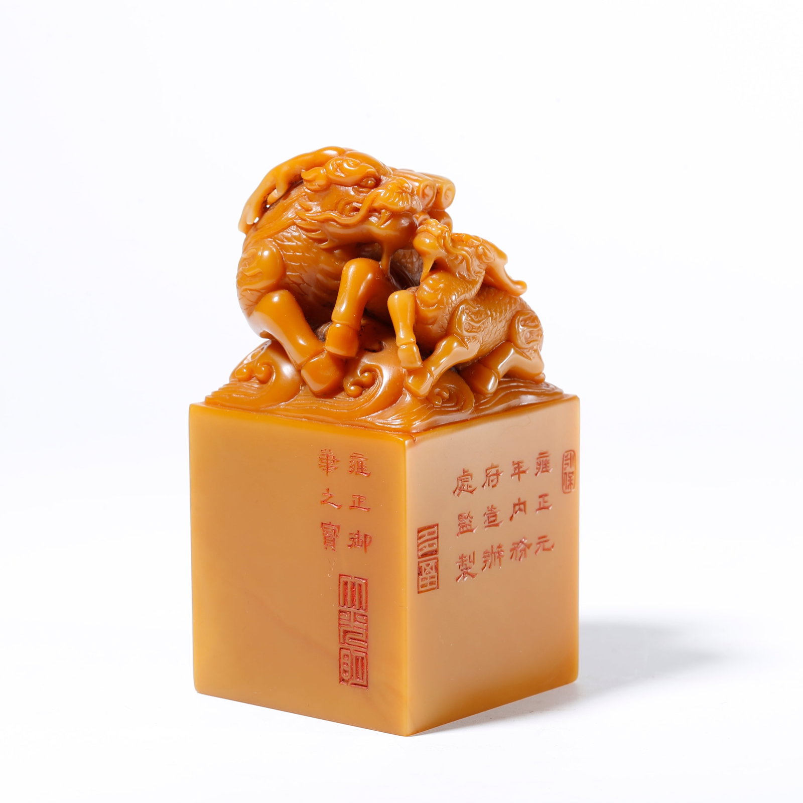 A SHOUSHAN TIANHUANG STONE SEAL WITH QILIN CARRYING BOOKS KNOB: Shoushan Tianhuang Stone Seal with Qilin Carrying Books Knob