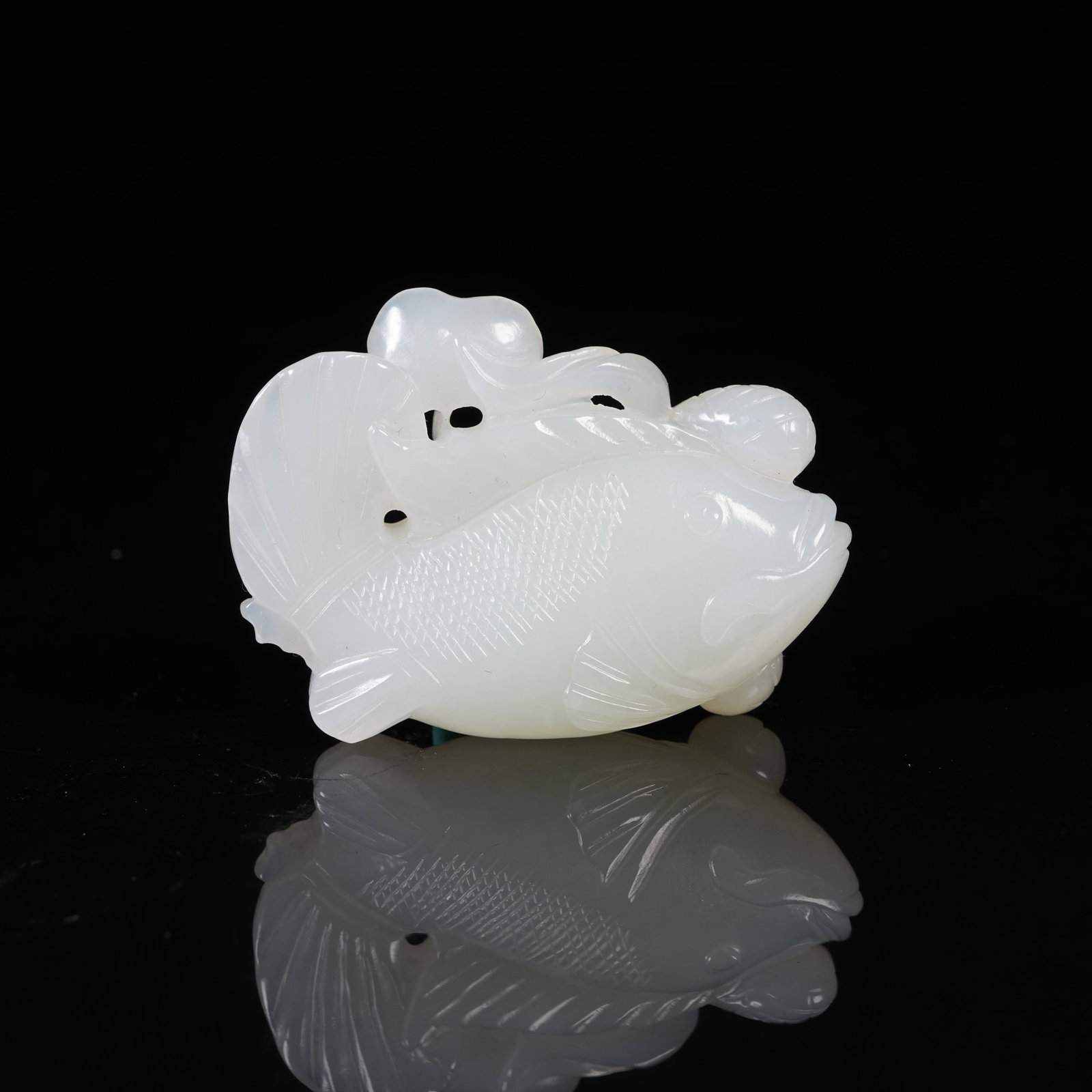 A WHITE HETIAN JADE PENDANT WITH CARP HOLDING LOTUS: White Hetian Jade Pendant with Carp Holding Lotus