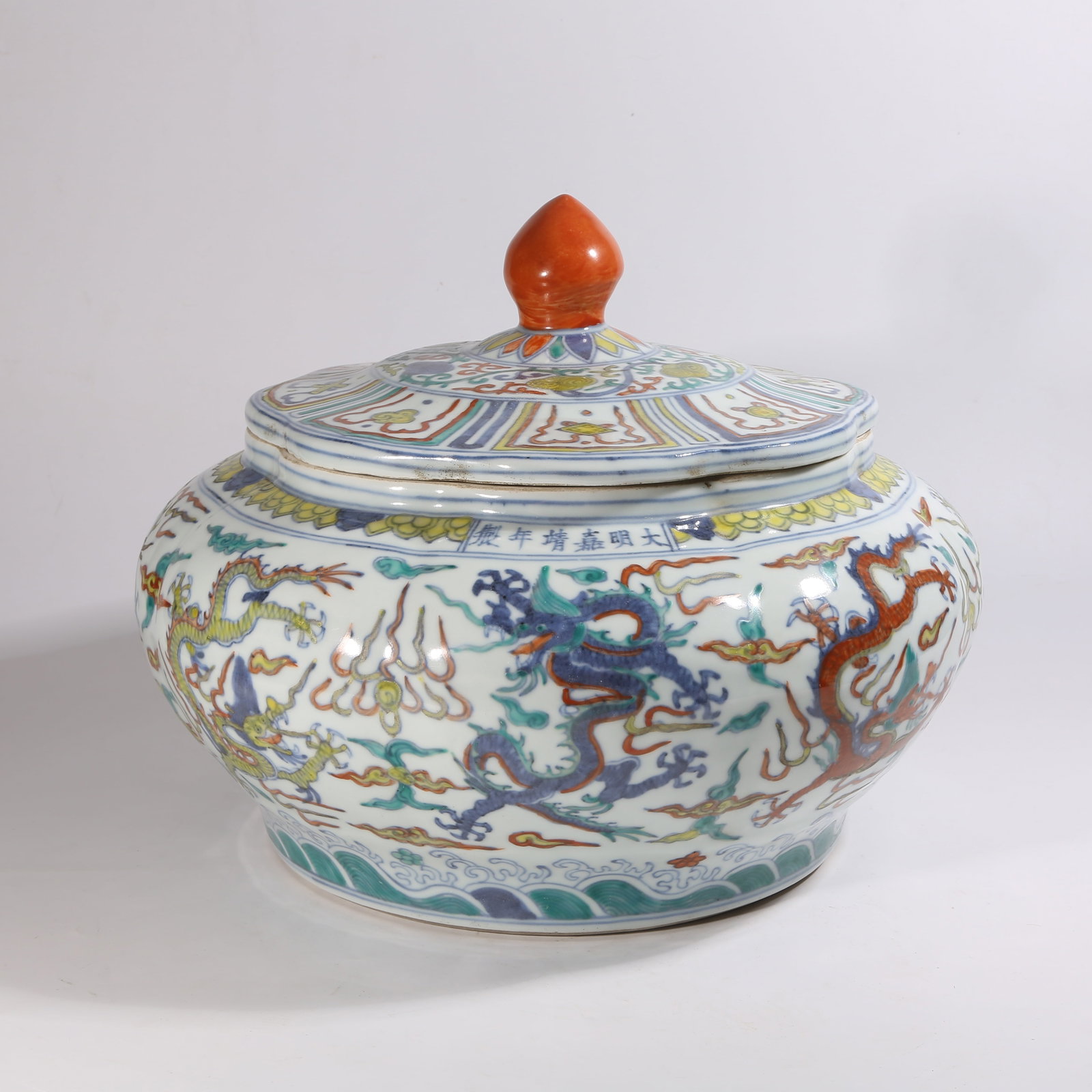 A DOUCAI COVERED JAR WITH GOURD-SHAPED RIBS AND "NINE DRAGONS PLAYING IN THE SEA" DESIGN: Doucai Covered Jar with Gourd-Shaped Ribs and "Nine Dragons Playing in the Sea" Design