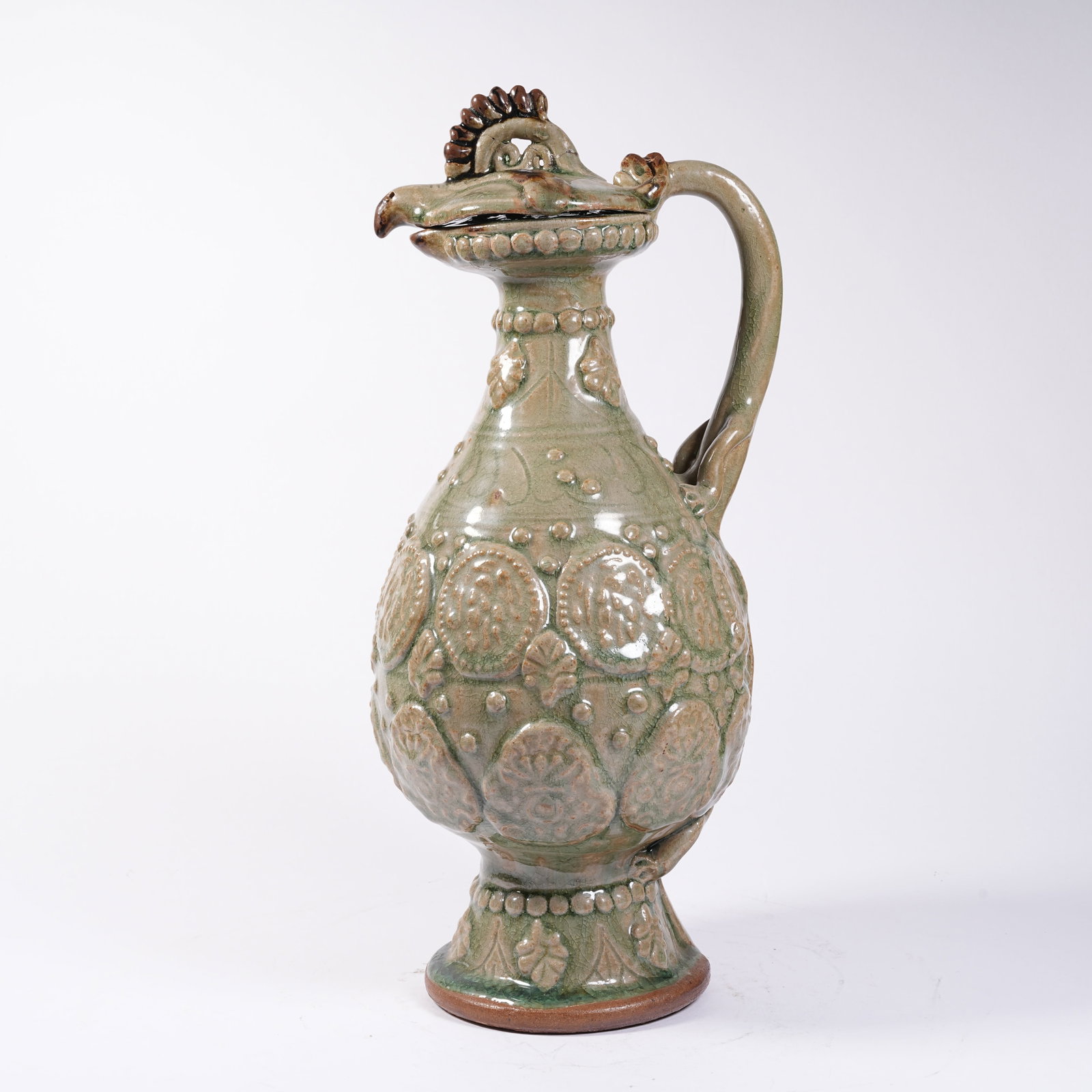 A CELADON PHOENIX-HEAD EWER WITH MOLDED FLORAL PATTERNS: Celadon Phoenix-head Ewer with Molded Floral Patterns
