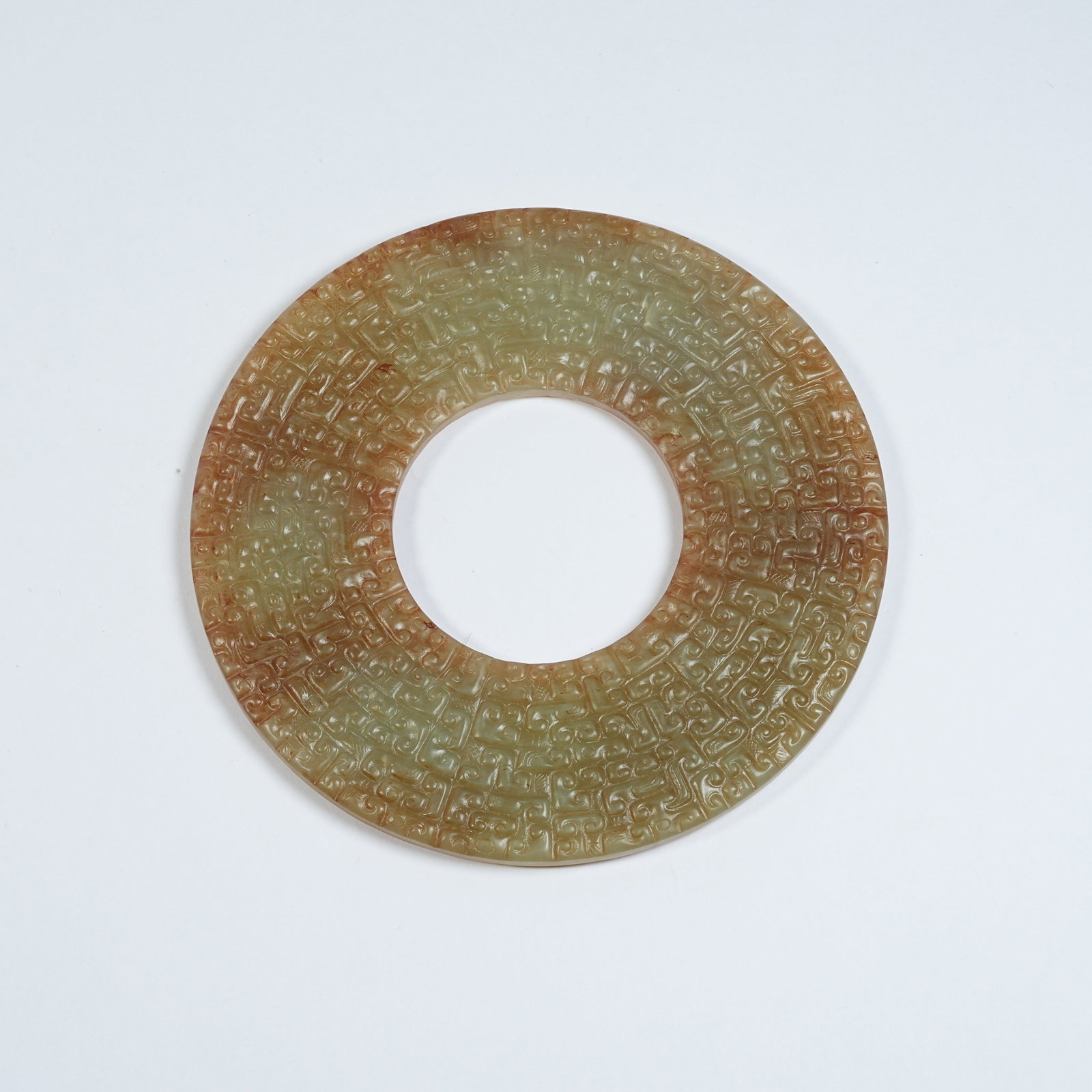 A ANCIENT JADE BI WITH INTERLOCKING CLOUD PATTERNS: Ancient Jade Bi with Interlocking Cloud Patterns