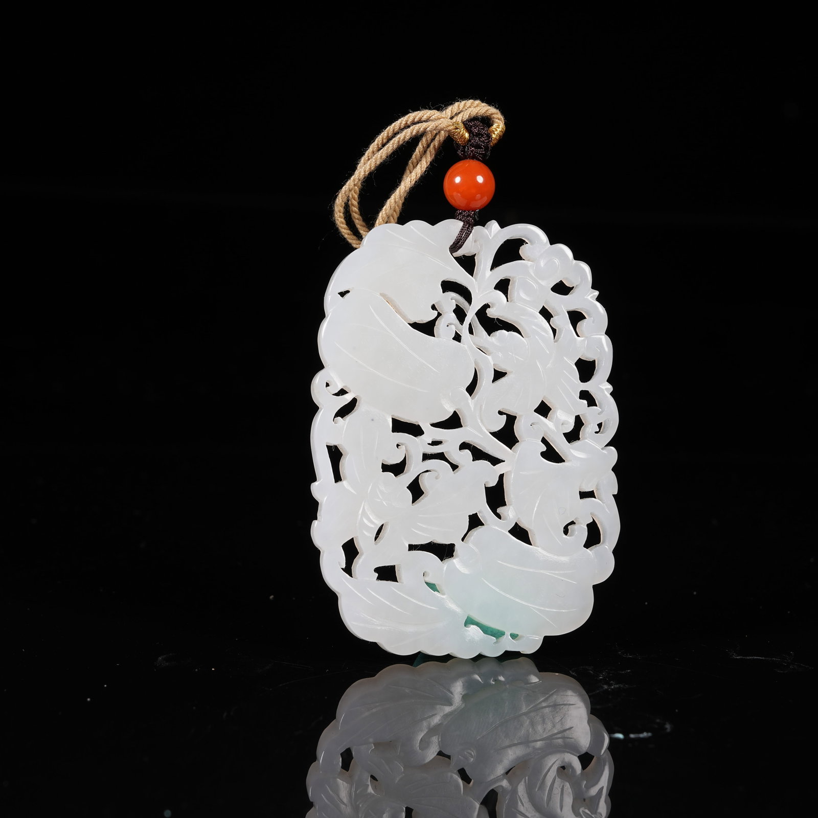 A WHITE HETIAN JADE PENDANT WITH FLOWER AND BUTTERFLY PATTERNS: White Hetian Jade Pendant with Flower and Butterfly Patterns