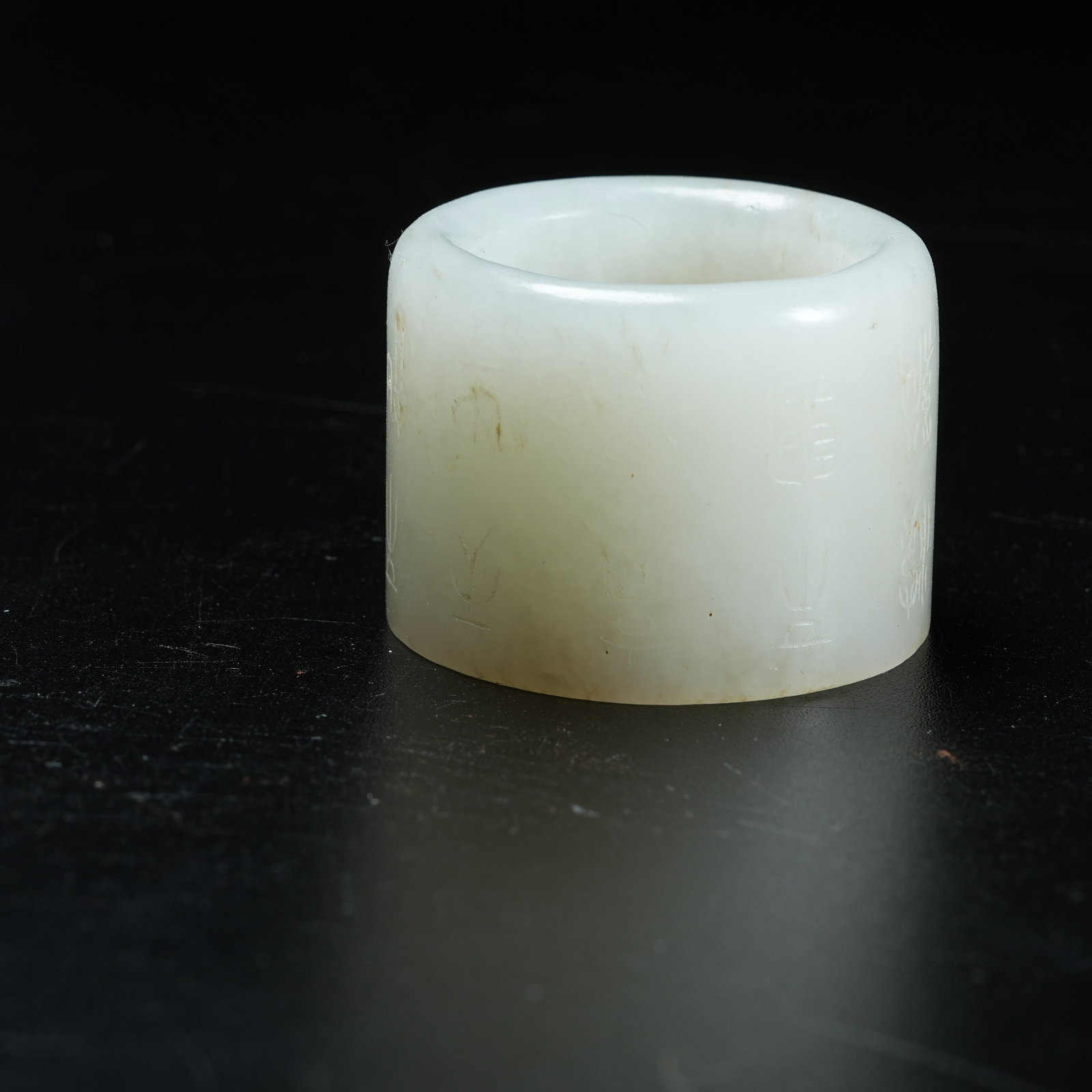 A HETIAN JADE THUMB RING WITH INSCRIPTIONS: Hetian Jade Thumb Ring with Inscriptions