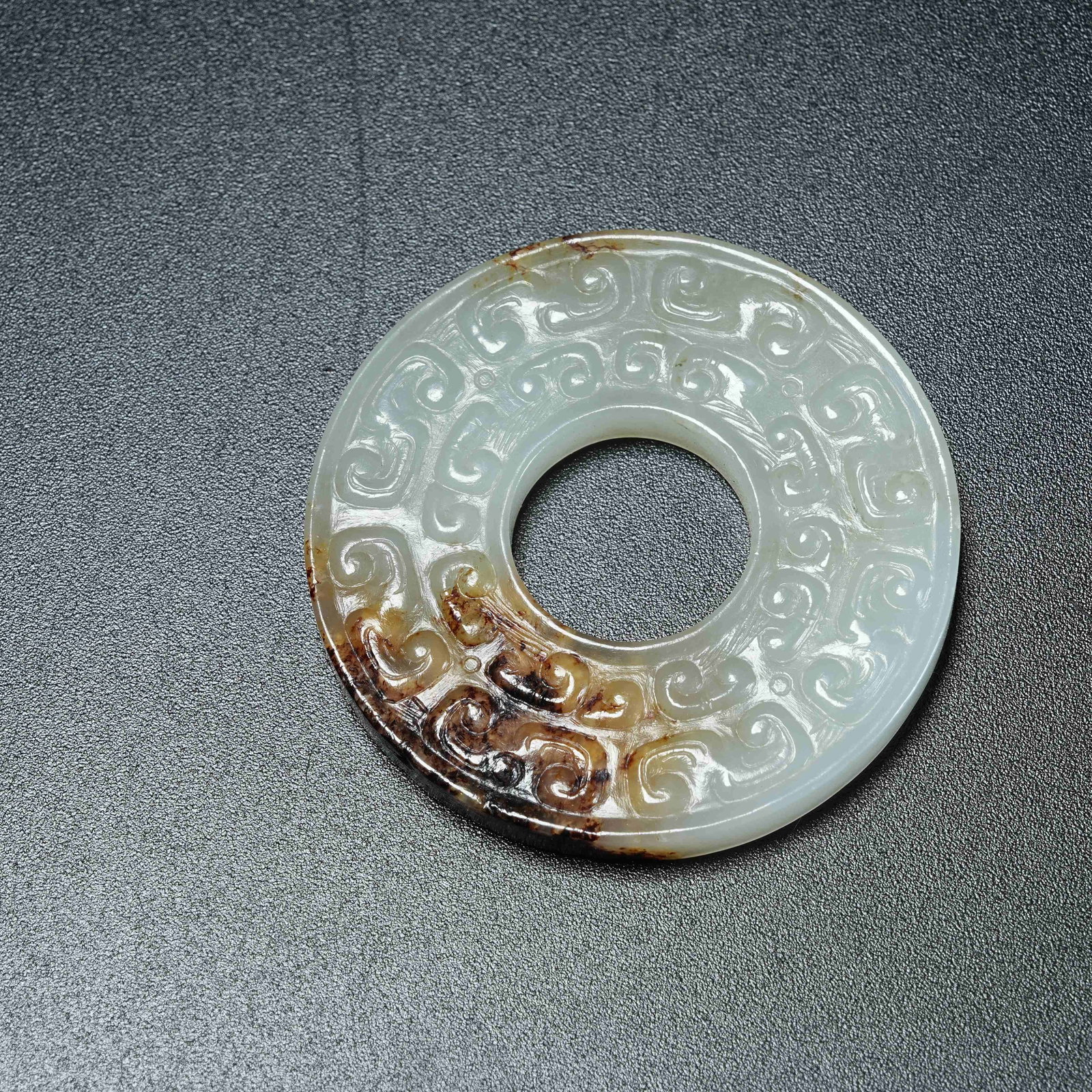 A ANCIENT JADE BI DISC WITH HOOKED CLOUD PATTERN: Ancient Jade Bi Disc with Hooked Cloud Pattern