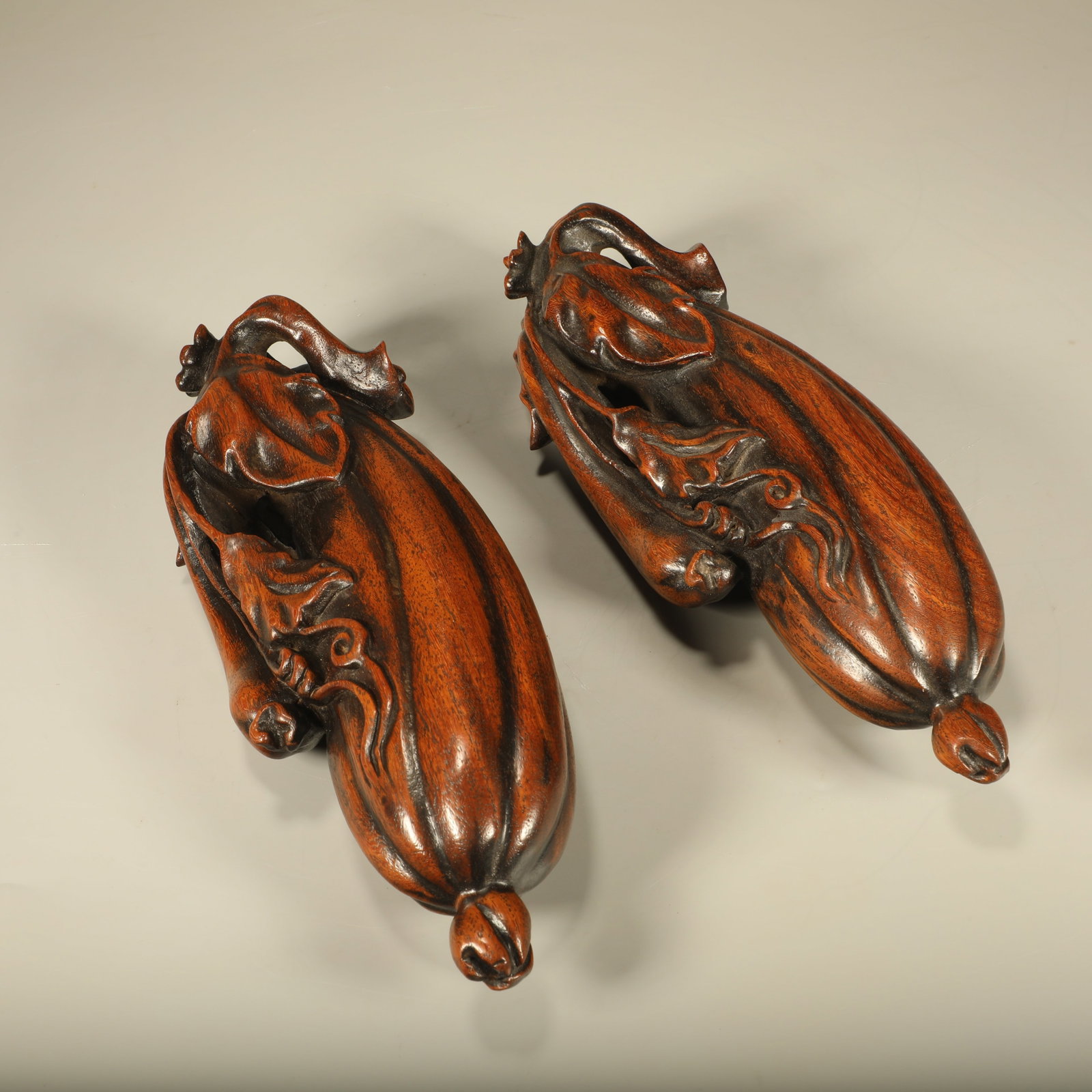 A PAIR OF HUANGHUALI PAPER WEIGHTS CARVED WITH CONTINUOUS-GOURD-VINE MOTIFS (1 of 7)
