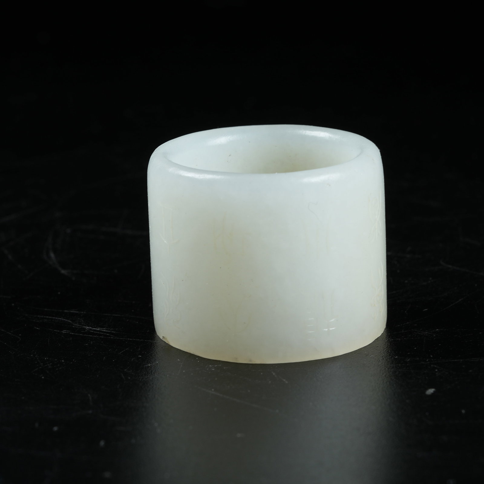 A HETIAN JADE THUMB RING WITH INSCRIPTIONS: Hetian Jade Thumb Ring with Inscriptions