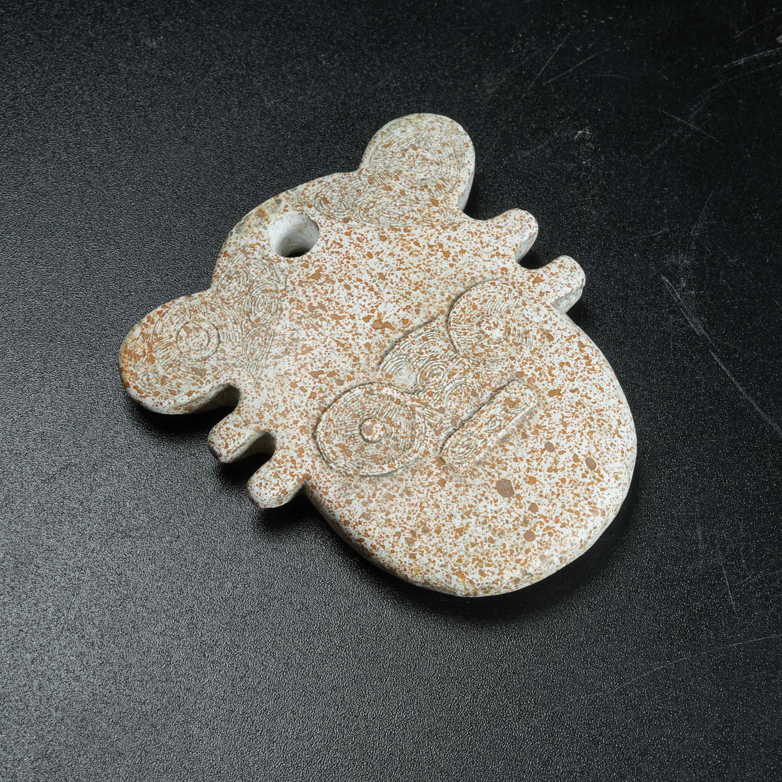A ANCIENT JADE PENDANT CARVED WITH DIVINE HUMAN FACE MOTIFS: Ancient Jade Pendant Carved with Divine Human Face Motifs
