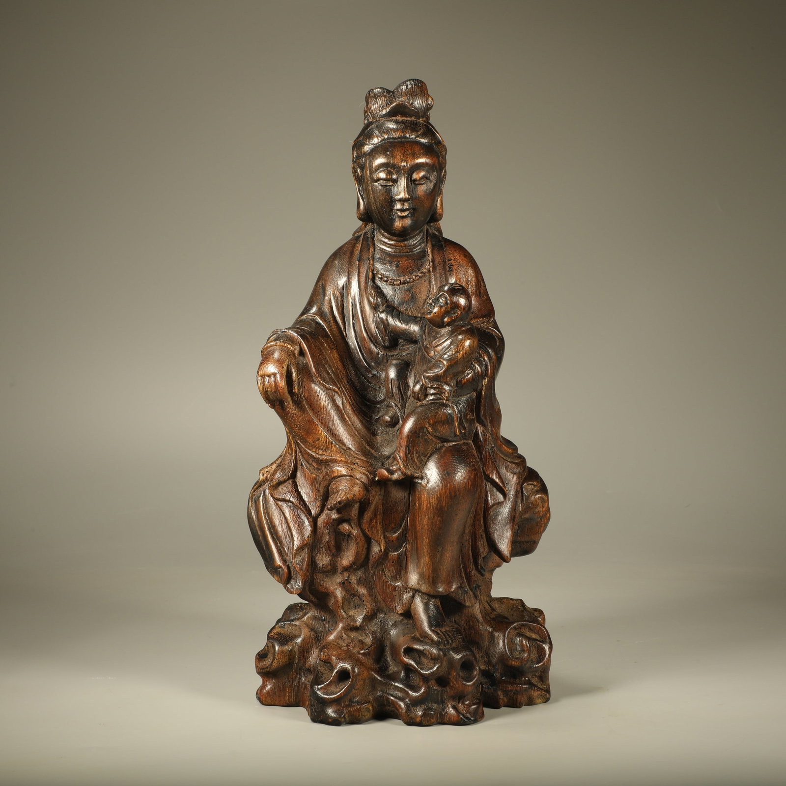 A CARVED CHENXIANG AVALOKITESVARA BRINGING A CHILD (1 of 7)