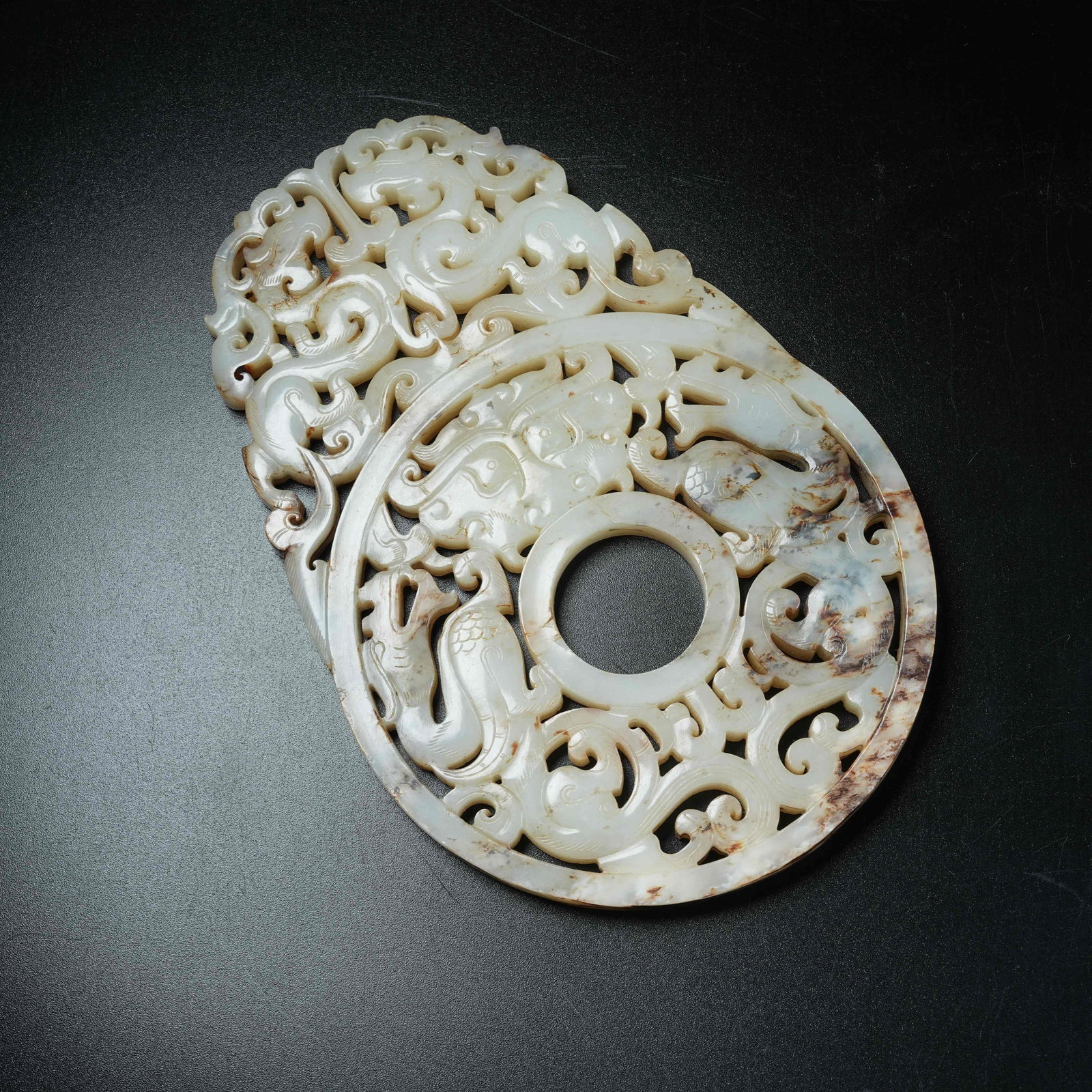A ANCIENT JADE OPENWORK BI DISC CARVED WITH CHI DRAGON AND BEAST MASK PATTERNS EXTENDING BEYOND RIM (1 of 9)