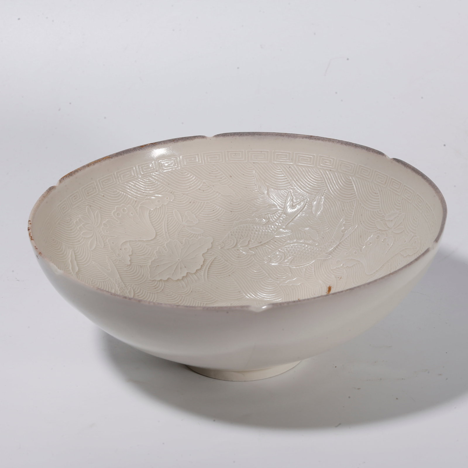 A DING KILN MOULD-IMPRESSED MALLOW-MOUTHED BOWL WITH FISH AND ALGAE PATTERN: Ding kiln mould-impressed mallow-mouthed bowl with fish and algae pattern