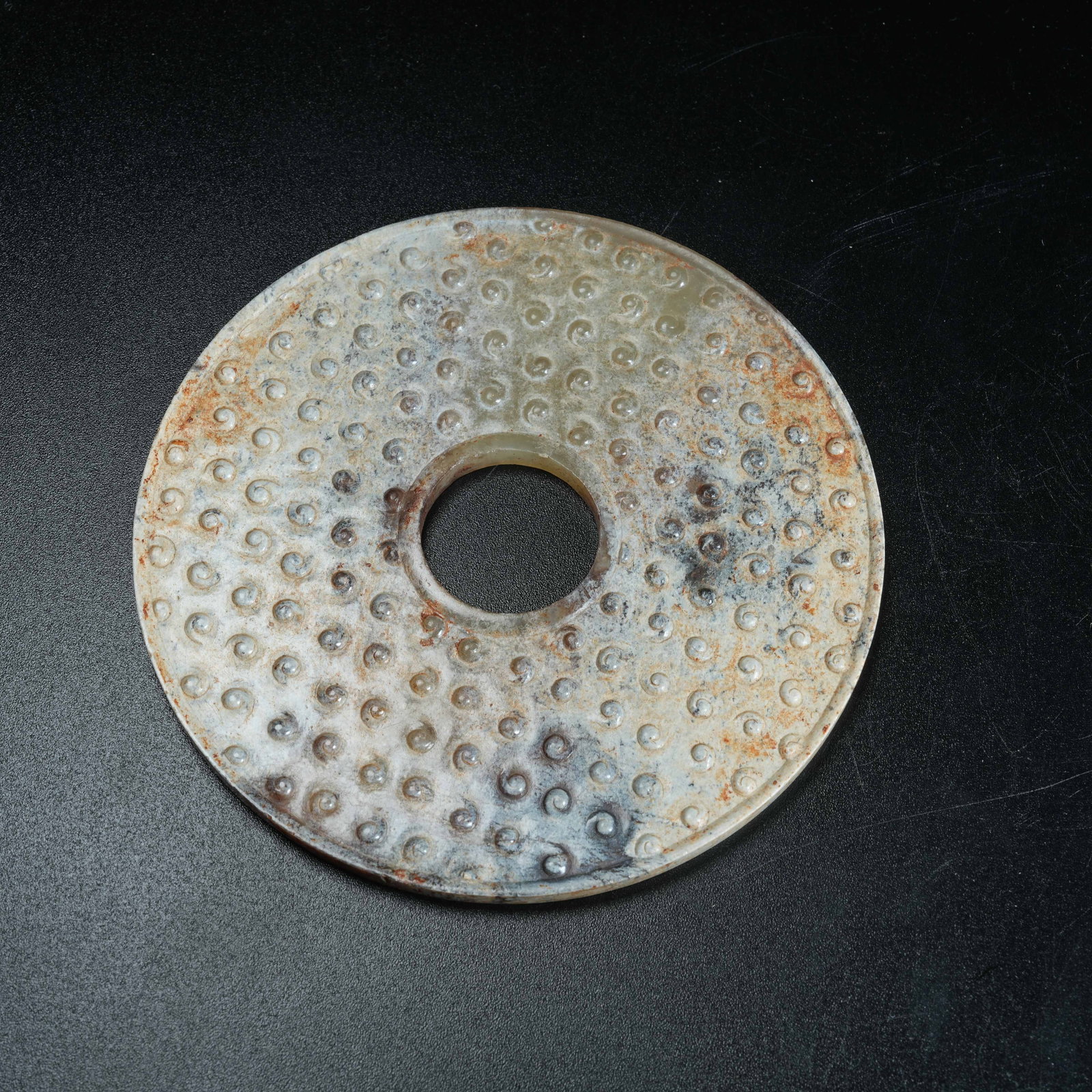 A ANCIENT JADE BI DISC CARVED WITH NAIL BOSS PATTERNS: Ancient Jade Bi Disc Carved with Nail Boss Patterns