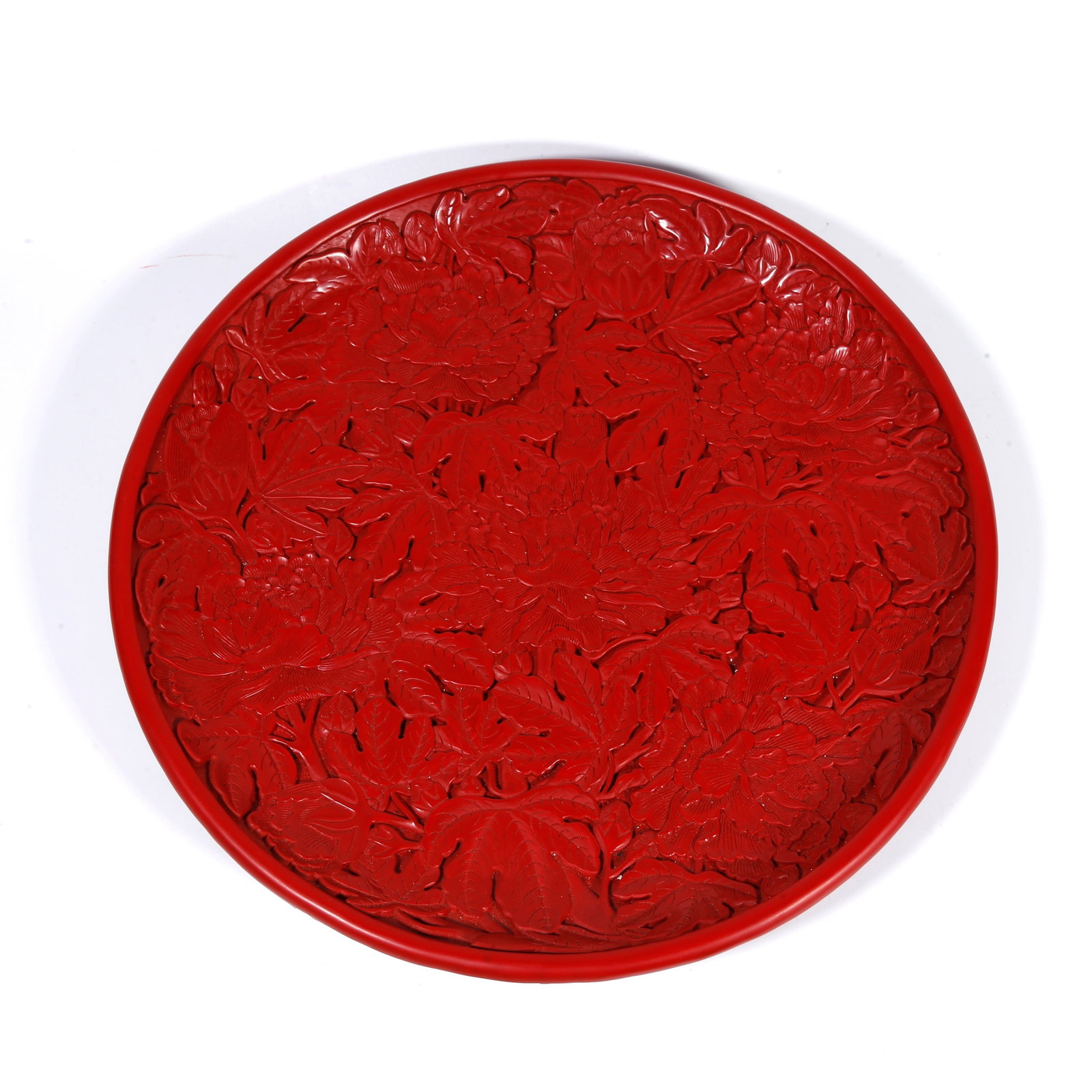 A CARVED-RED PLATE WITH FLOWER PATTERN: Carved-red plate with flower pattern