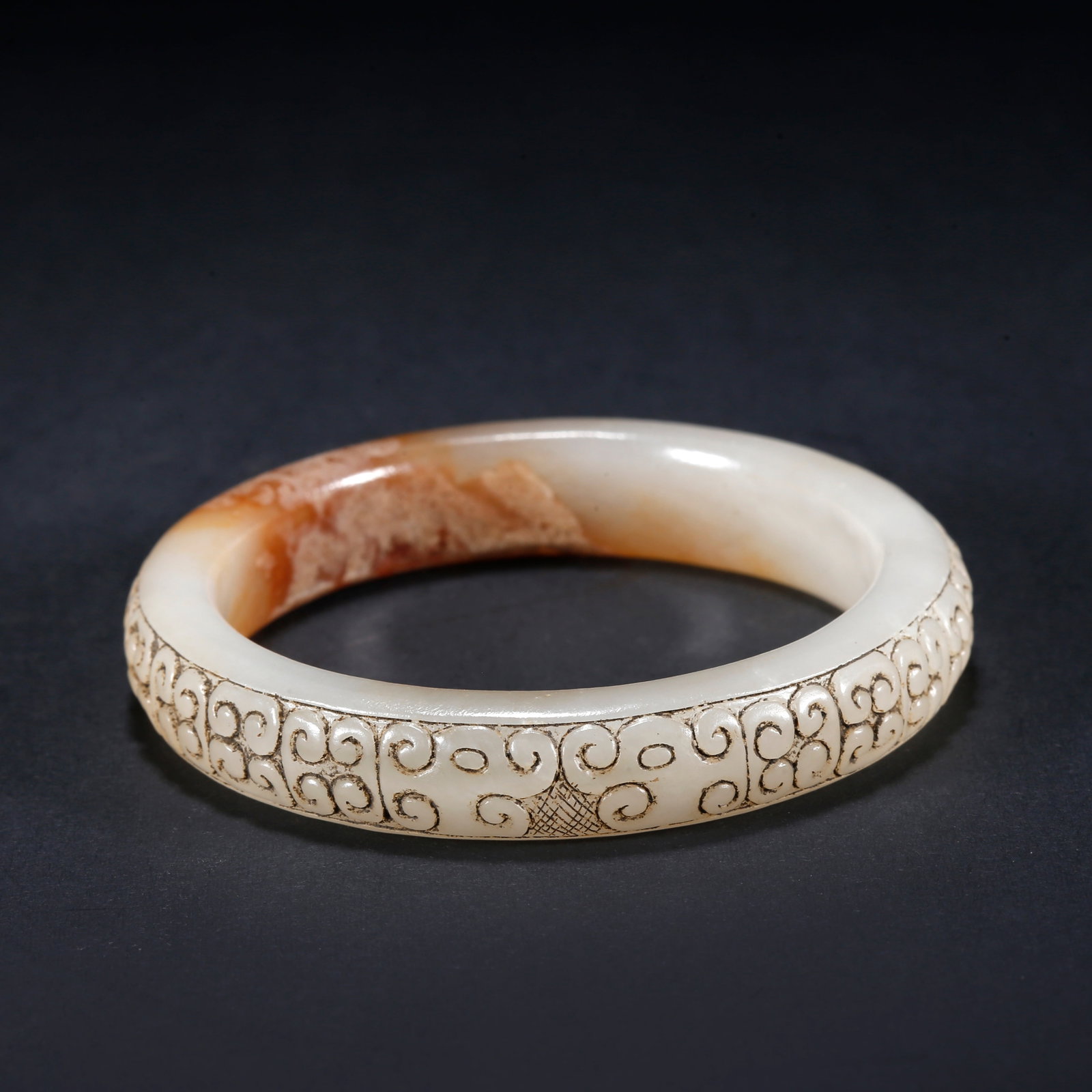 A HETIAN JADE BRACELET CARVED WITH AUSPICIOUS CLOUD PATTERN: Hetian Jade Bracelet Carved with Auspicious Cloud Pattern